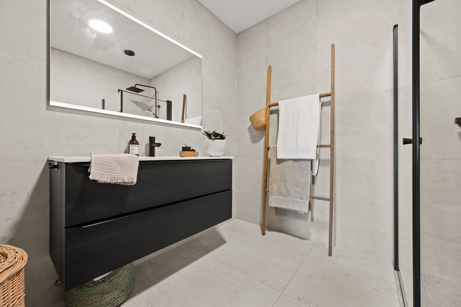 Badet i underetasjen er innredet i tilsvarende stil som badet i andre etasje, og er utstyrt med dusjhjørne, vegghengt toalett og baderomsinnredning med nedfelt servant. Galleribilde