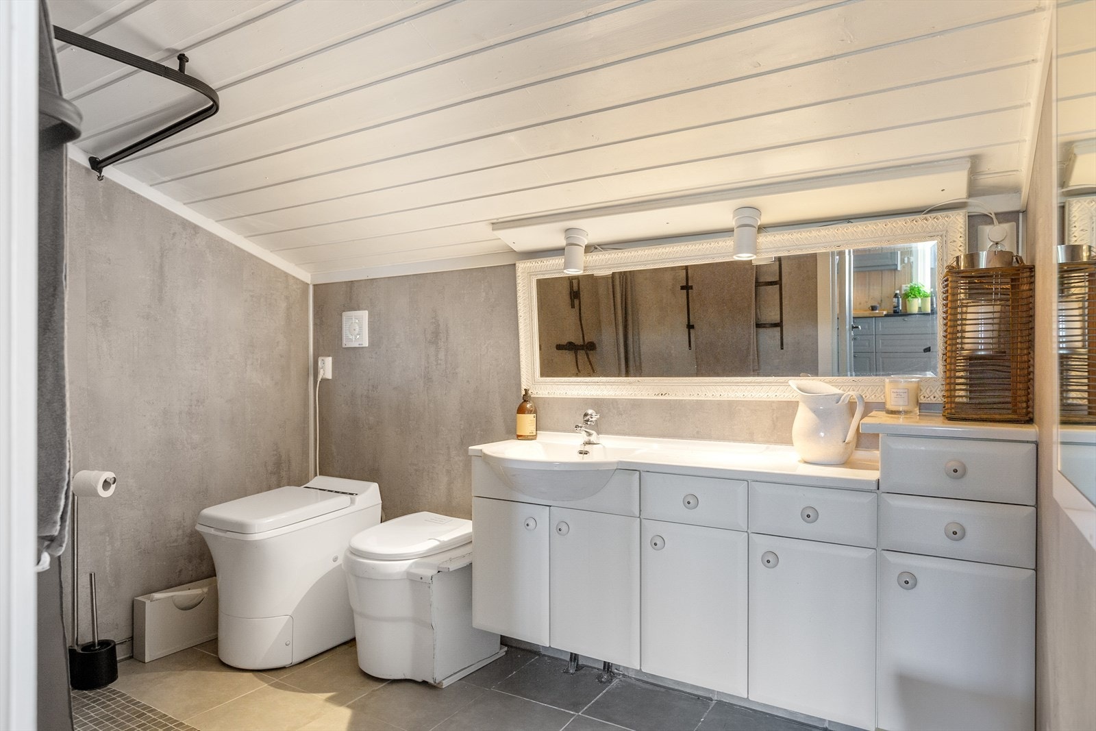 Badet ble oppgradert i 2022 og har flislagt gulv med varmekabler, mens veggene er kledd med baderomsplater. I tillegg til baderomsinnredning og dusj på vegg, er det her urinal og forbrenningstoalett. Galleribilde
