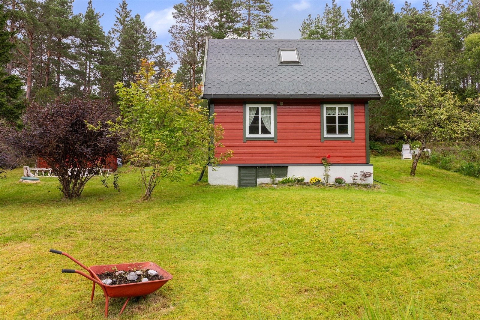 Tomten er opparbeidet med plenarealer og naturtomt. Galleribilde