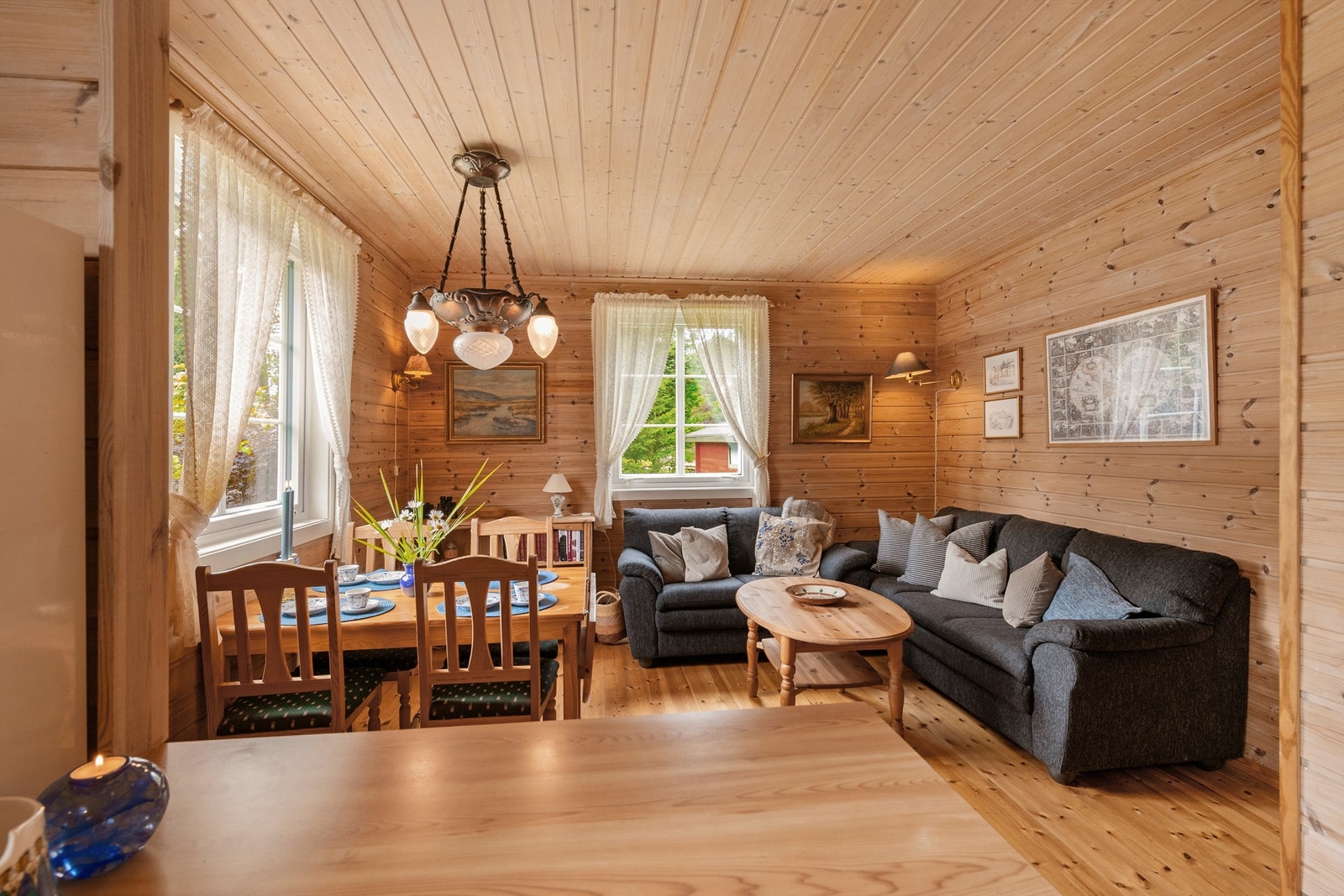 Stuen har plass til både sofagruppe og spisebord, med furubord på gulvet. Galleribilde
