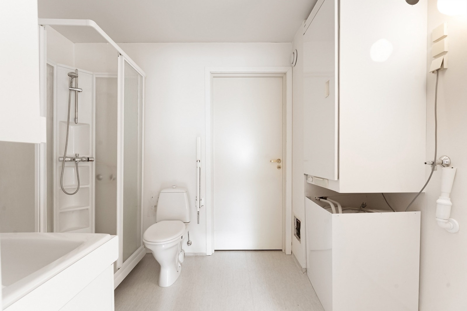 Badet er innredet med dusjkabinett, toalett, tørkeskap og opplegg for vaskemaskin. Galleribilde