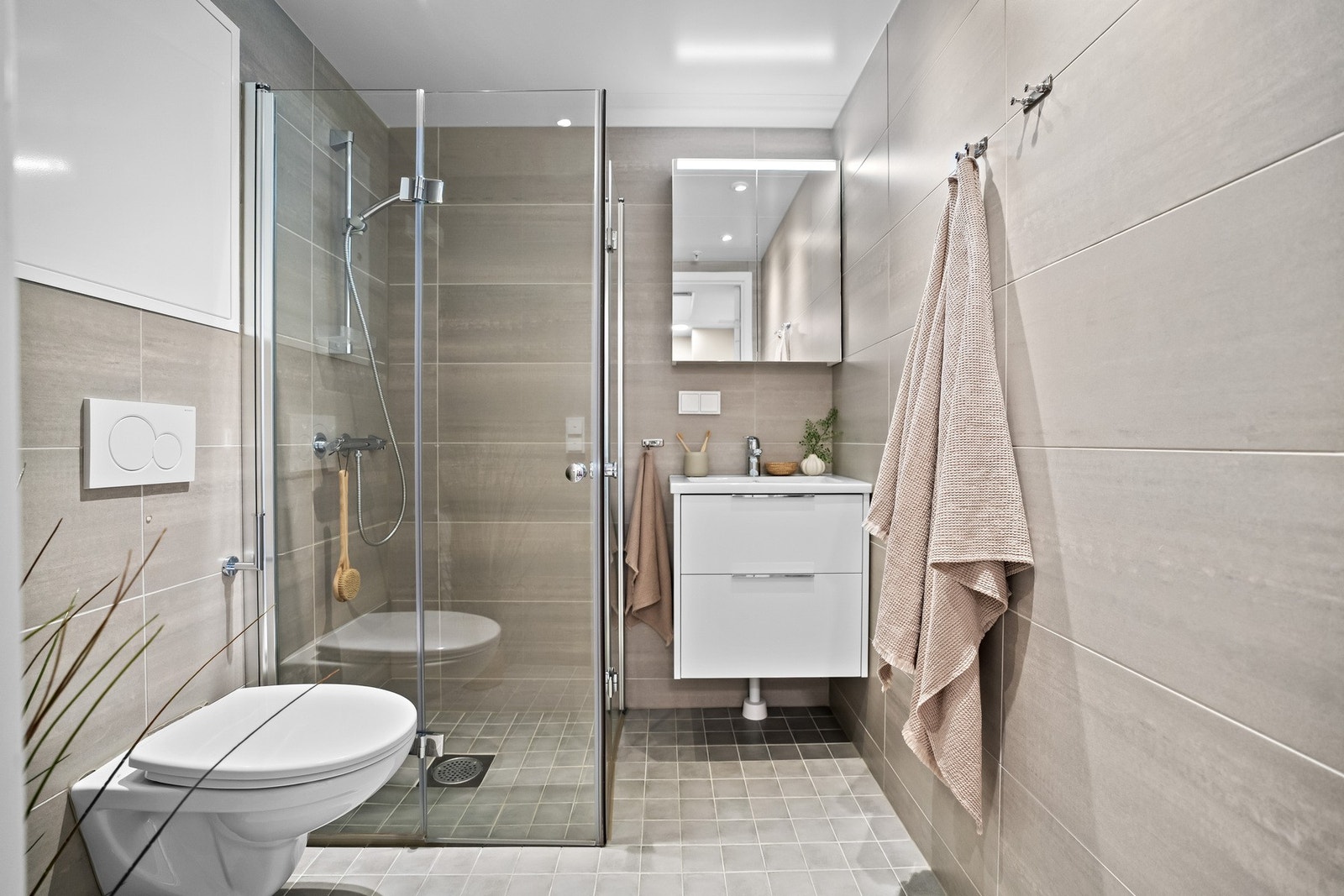 Pent og funksjonelt bad med flislagte overflater og moderne innredning. Badet er utstyrt med gulvvarme, servant med oppbevaringsplass, toalett og dusjløsning. Et komfortabelt og tidsriktig bad som dekker hverdagens behov på en god måte. Galleribilde