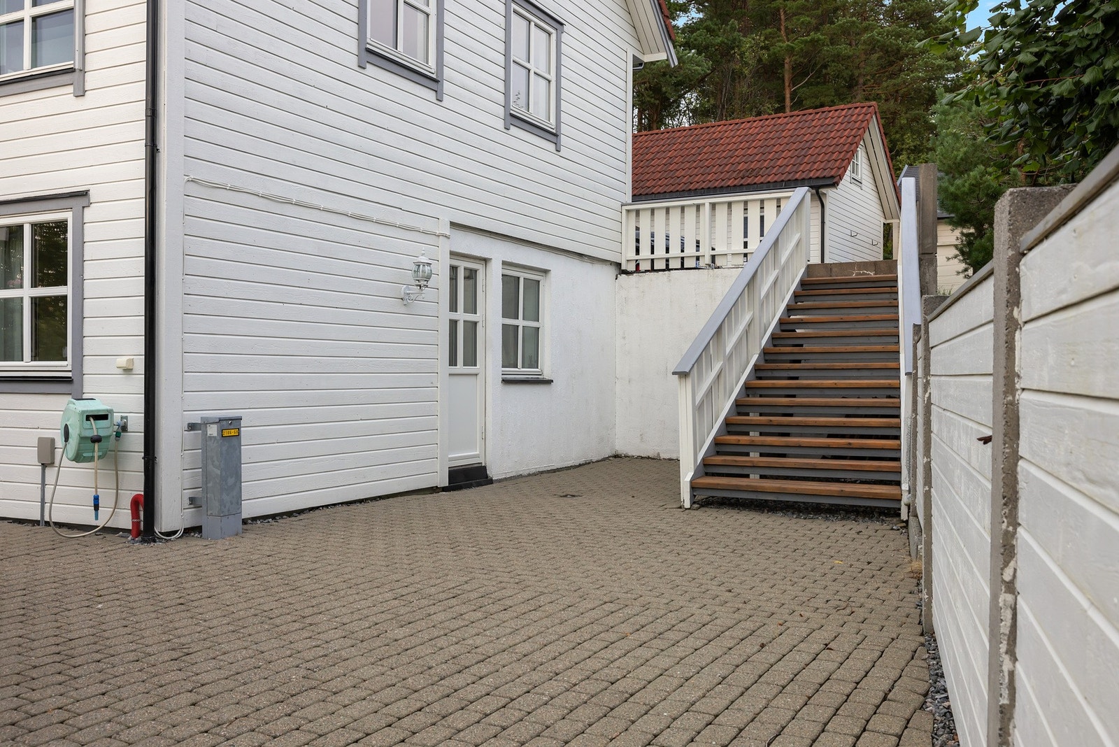 Flott terrasse med utførelse i brostein/belegningsstein og egen trapp opp til parkeringen. Galleribilde