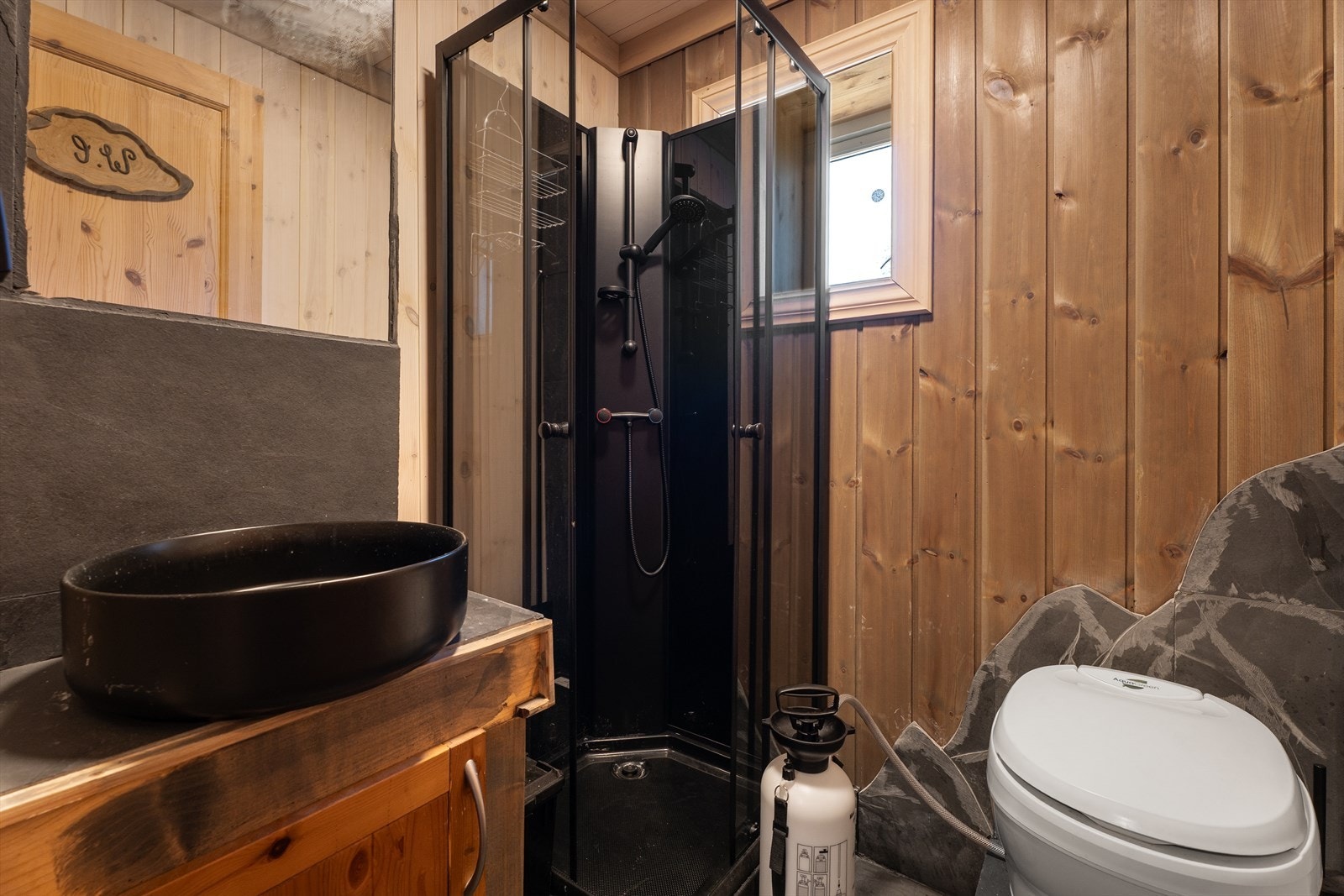 Dusj ved hjelp av pumpesystem, og toalett med vannbeholder ut til tett tank. Galleribilde