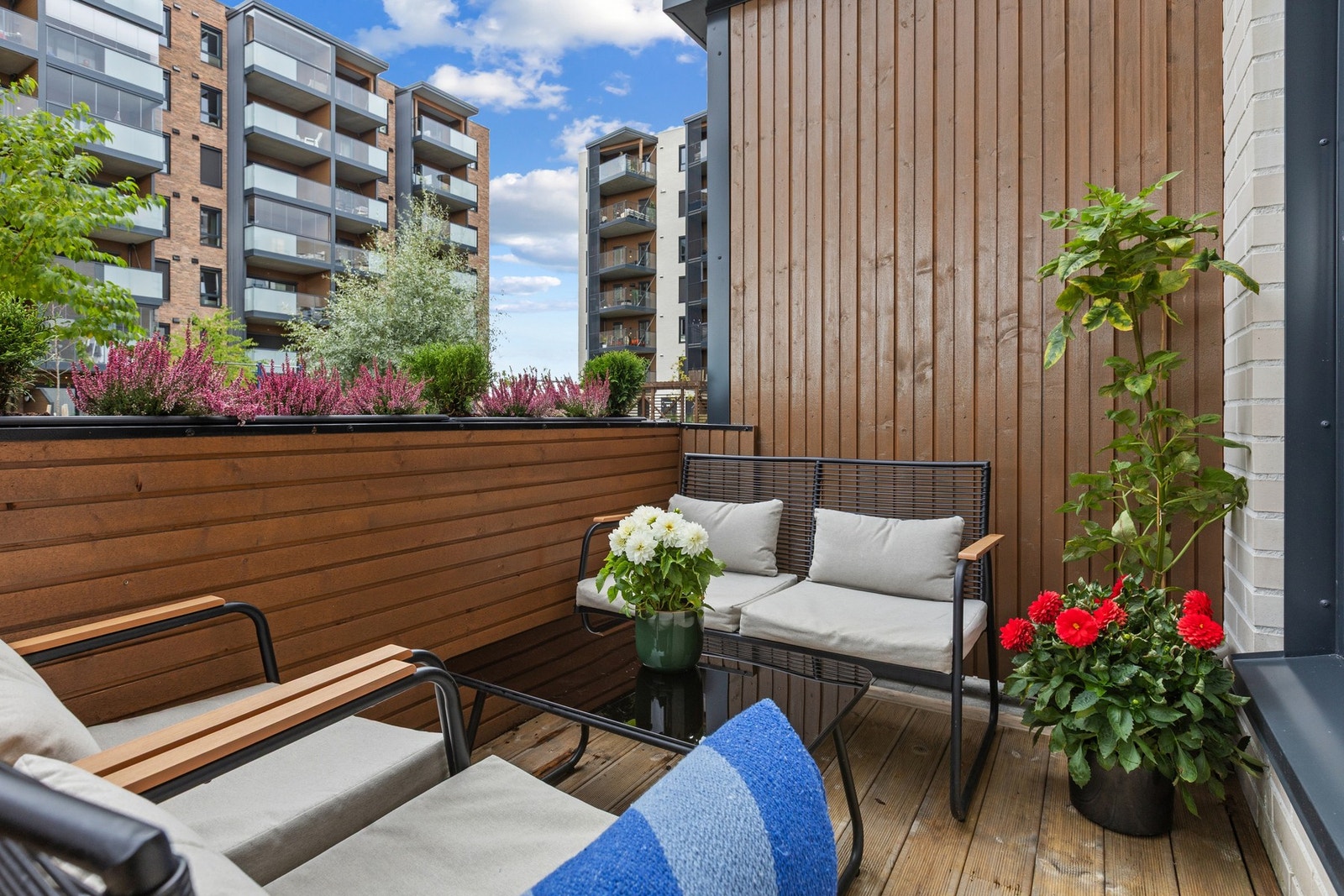 Terrassen fremstår som en lun og hyggelig uteplass med plass til sittegruppe og beplantning - perfekt for rolige stunder utendørs. Galleribilde