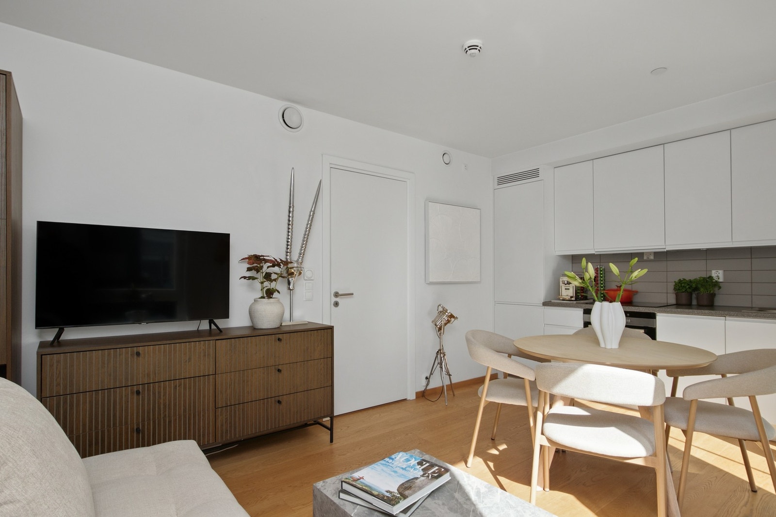 Innredningen har hvite, glatte fronter, takoppforede skap og grå laminatbenkeplate med nedfelt kum i stål. Galleribilde