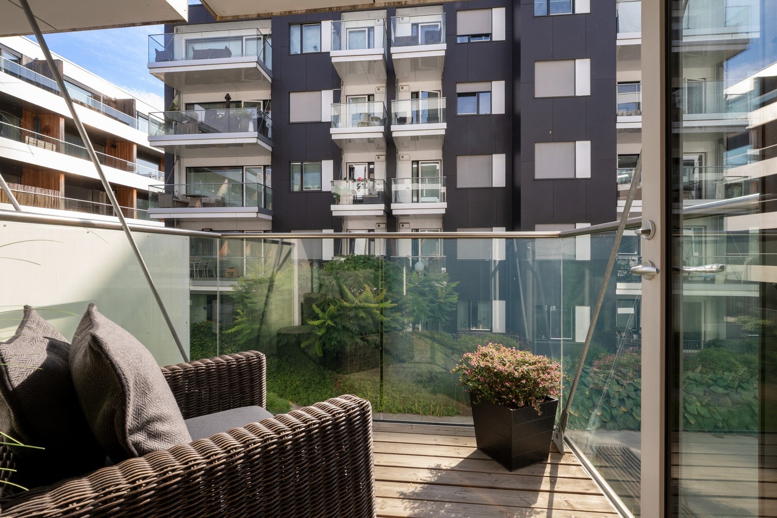 Uteplassen har rekkverk i glass, overbygg som skjermer og plass til utemøbler. Galleribilde
