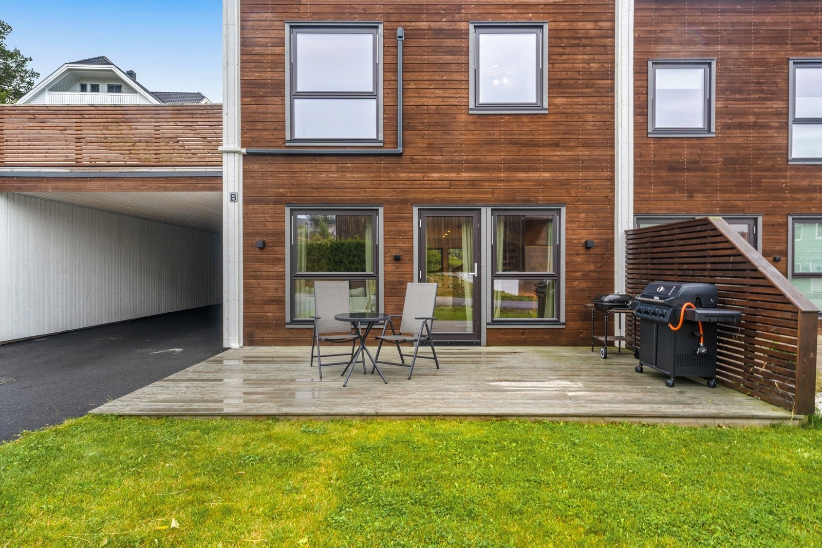 Markterrasse på bakkeplan med direkte utgang fra stuen og tilstøtende plenareal. Galleribilde