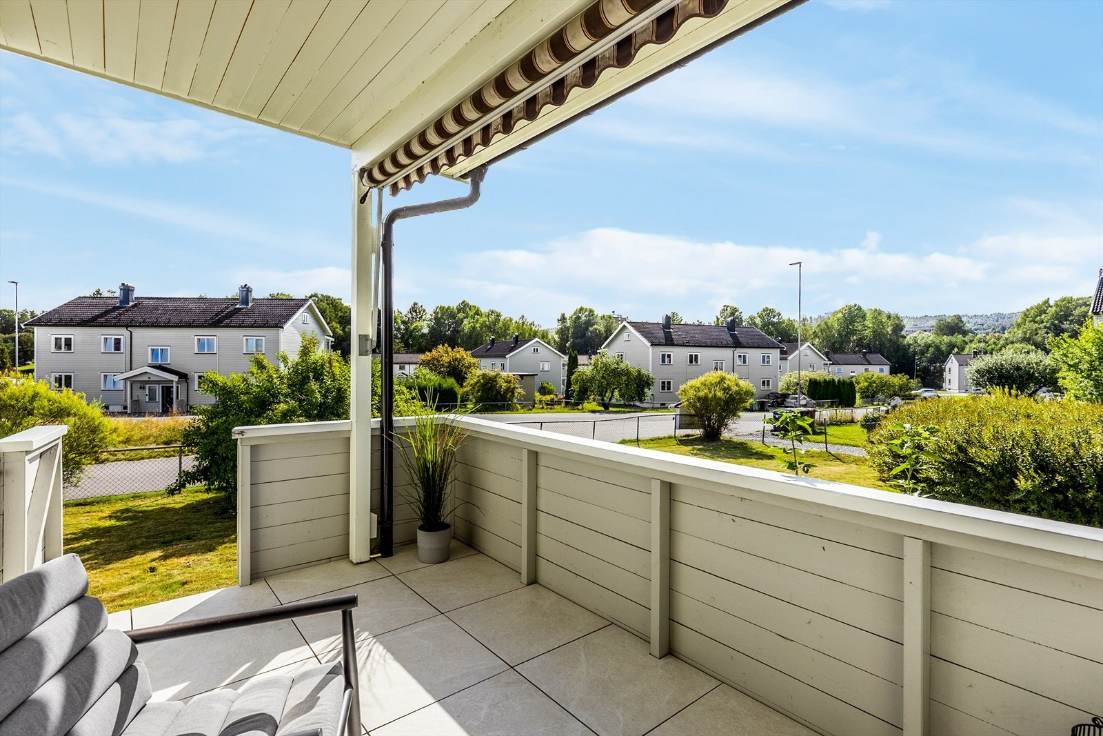 Fra verandaen har du fin utsikt over de grønne fellesarealene og det rolige nabolaget. Galleribilde