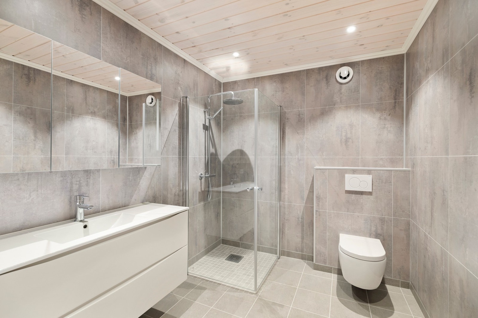 Badet i underetasjen er utstyrt med gulvvarme, åpen dusjnisje med glassvegger, baderomsinnredning, downlights og veggholdt toalett Galleribilde