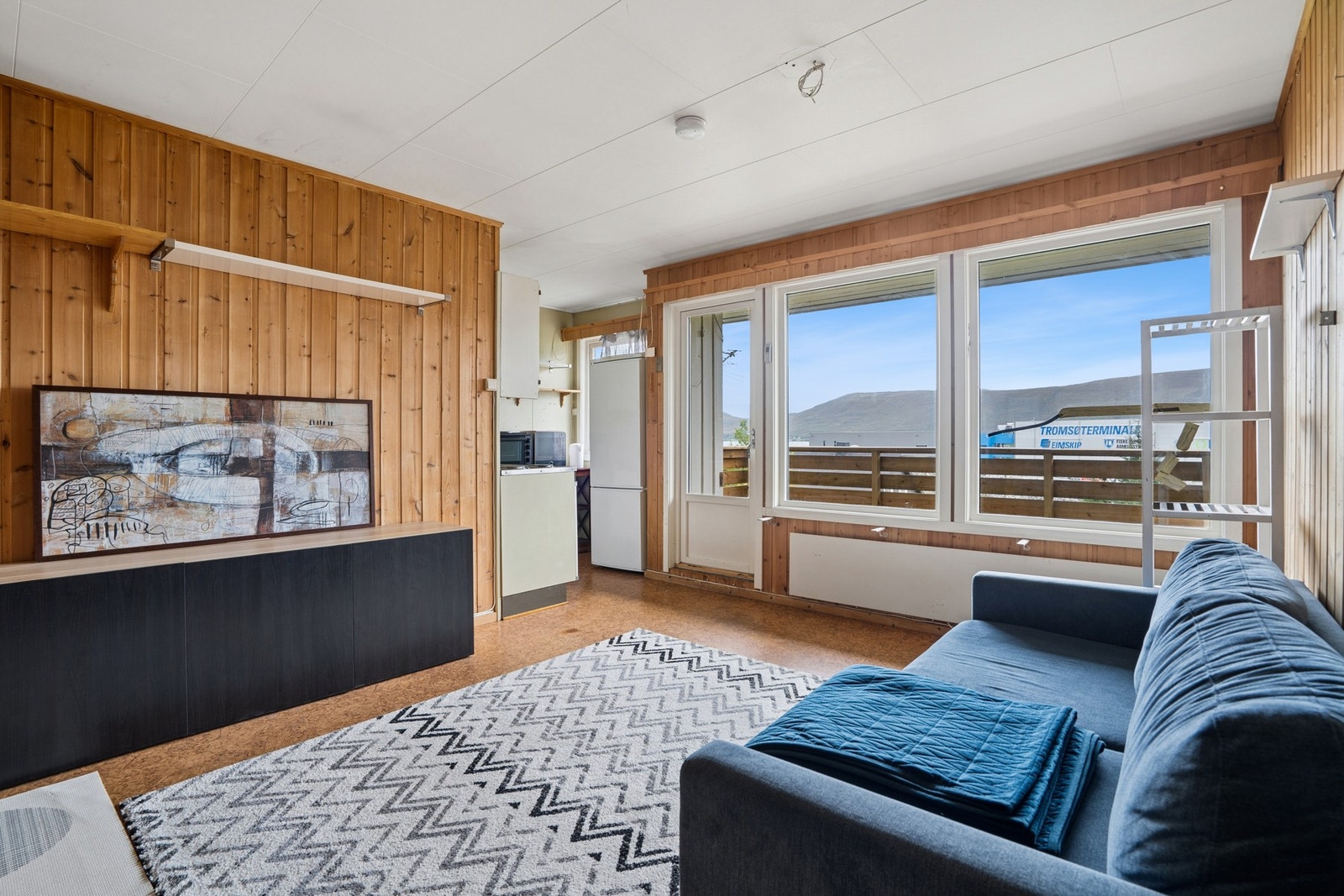 Stuen har panelkledde vegger, store vinduer og utgang til balkongen. Galleribilde