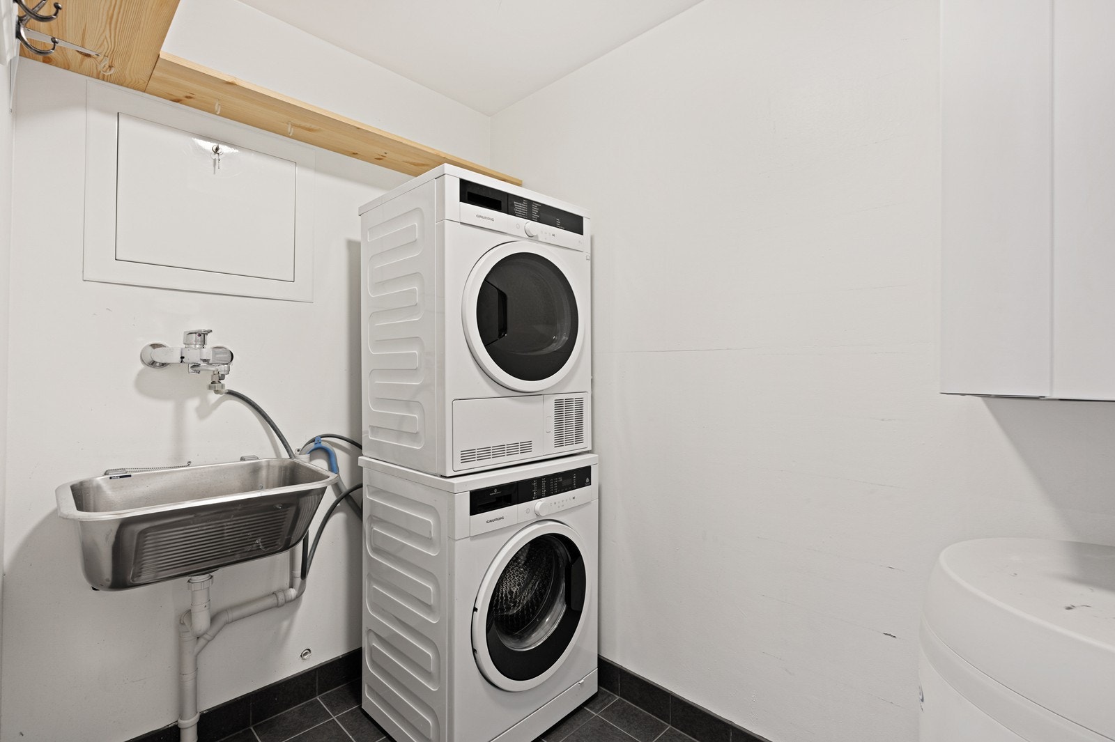 Vaskerom med opplegg for vaskemaskin og skyllekar i stål. Galleribilde