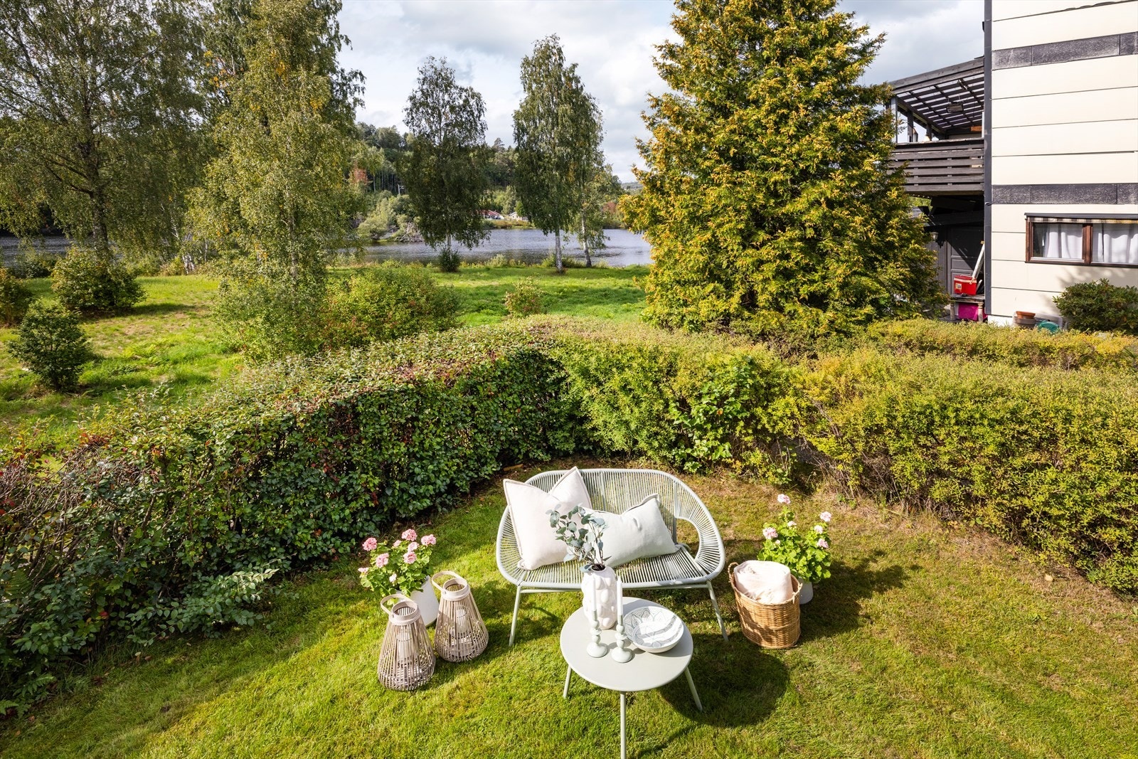 Uteplass i hagen med utsikt mot elva og omkringliggende natur. Galleribilde