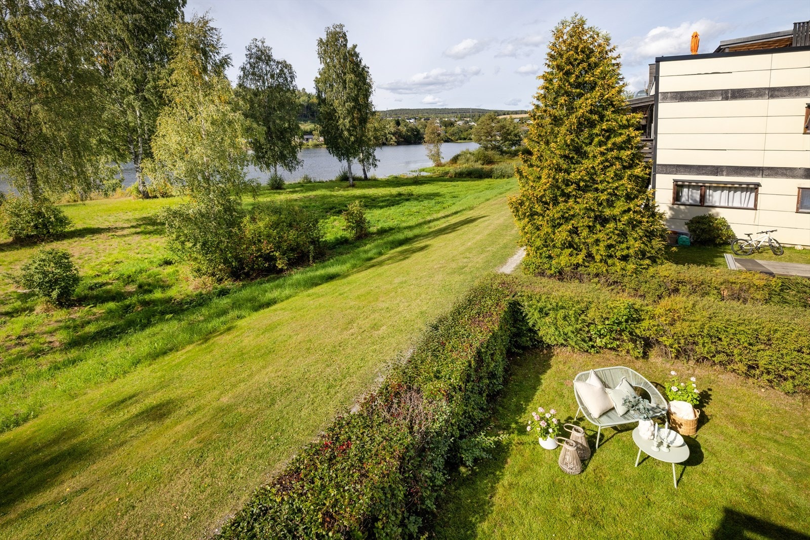 Utsikt fra terrassen ned mot hagen og elveløpet nedenfor. Galleribilde