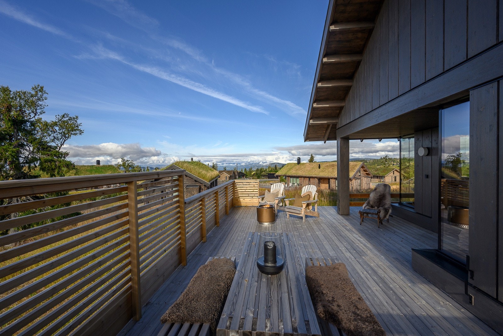 Sørvestvendt terrasse i treverk med god plass til sittegruppe og bålpanne. Galleribilde