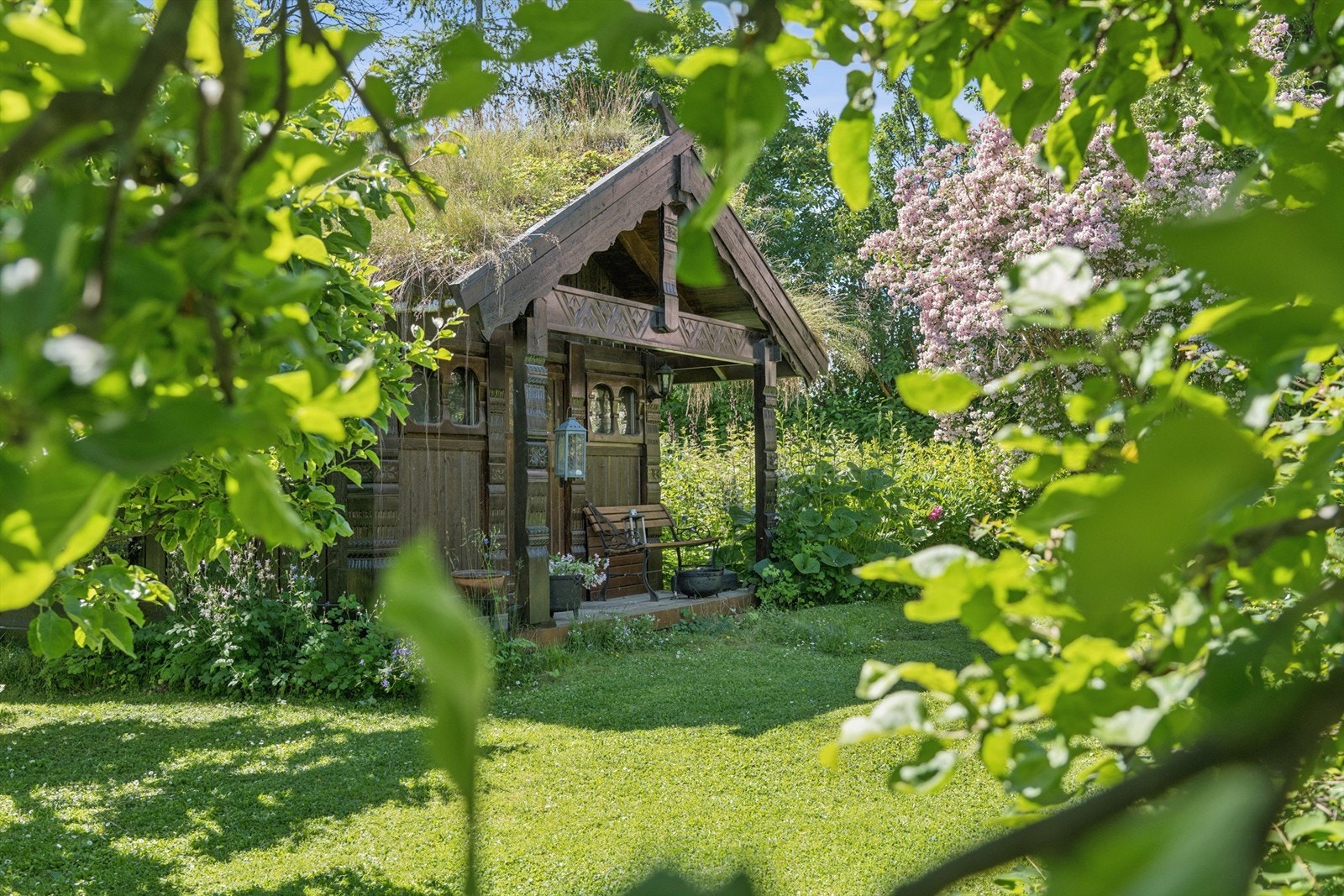 I den frodige hagen ligger vakkert lite byggverk fra Buen i Telemark Galleribilde
