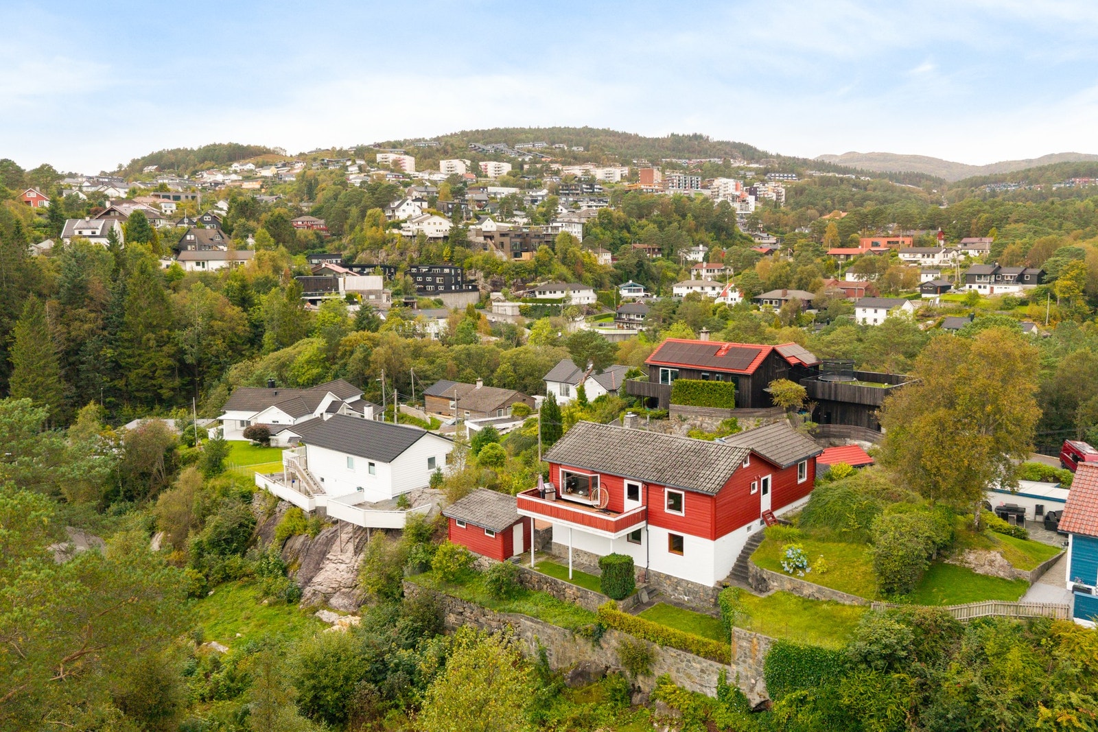 Boligen ligger fint tilbaketrukket på tomten, omgitt av grønne utearealer. Galleribilde