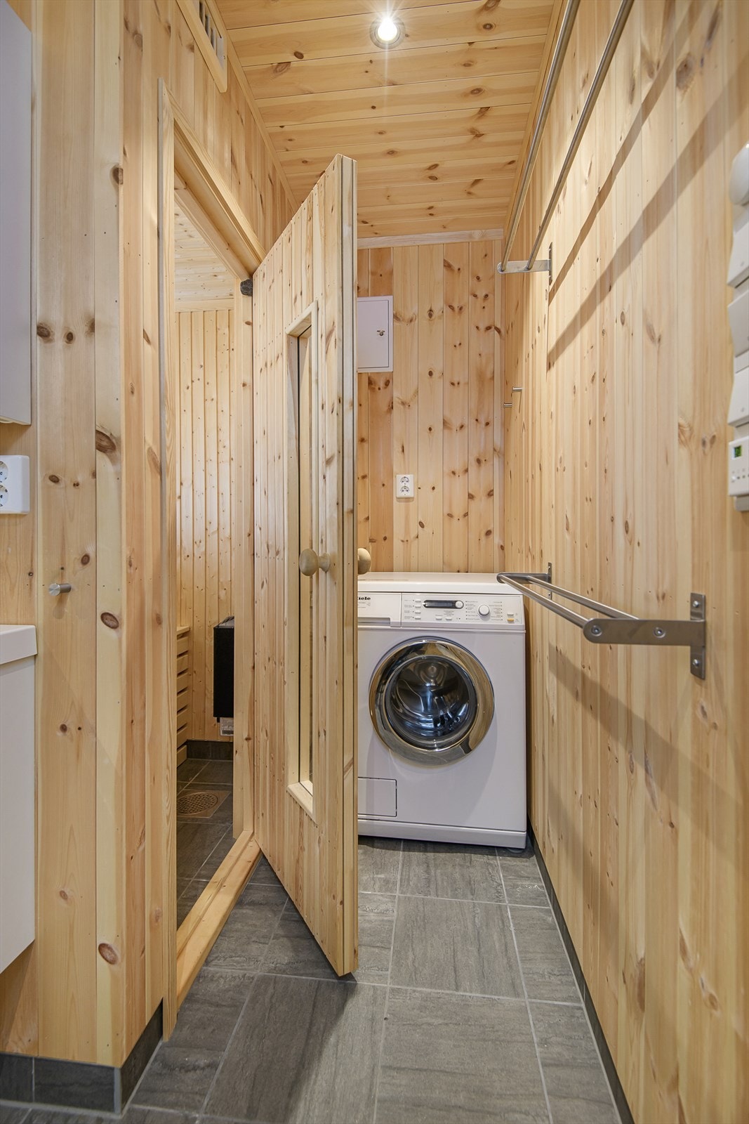 Badstue med sittebenker og elektrisk badstueovn. Opplegg for vaskemaskin. Galleribilde