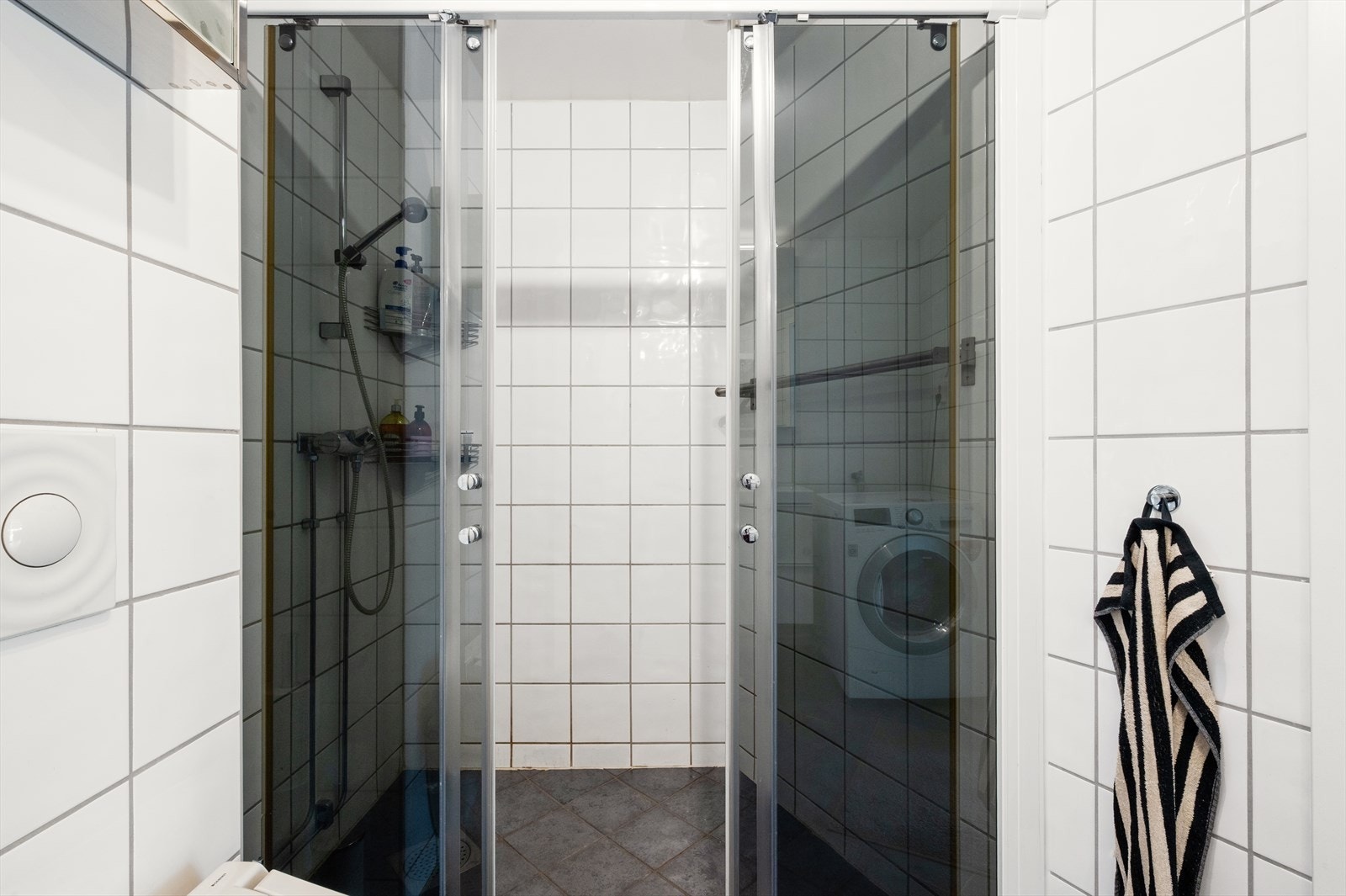 Badet er funksjonelt innredet med servant i baderomsinnredning med gode oppbevaringsmuligheter, speilskap, toalett og dusj med praktiske skyvbare dusjdører. Galleribilde