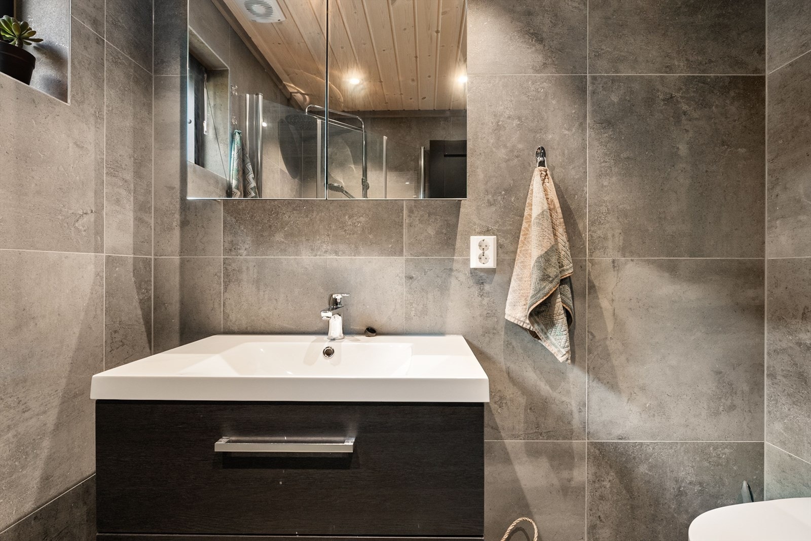 Badet har vegghengt toalett og speil med integrert belysning. Galleribilde