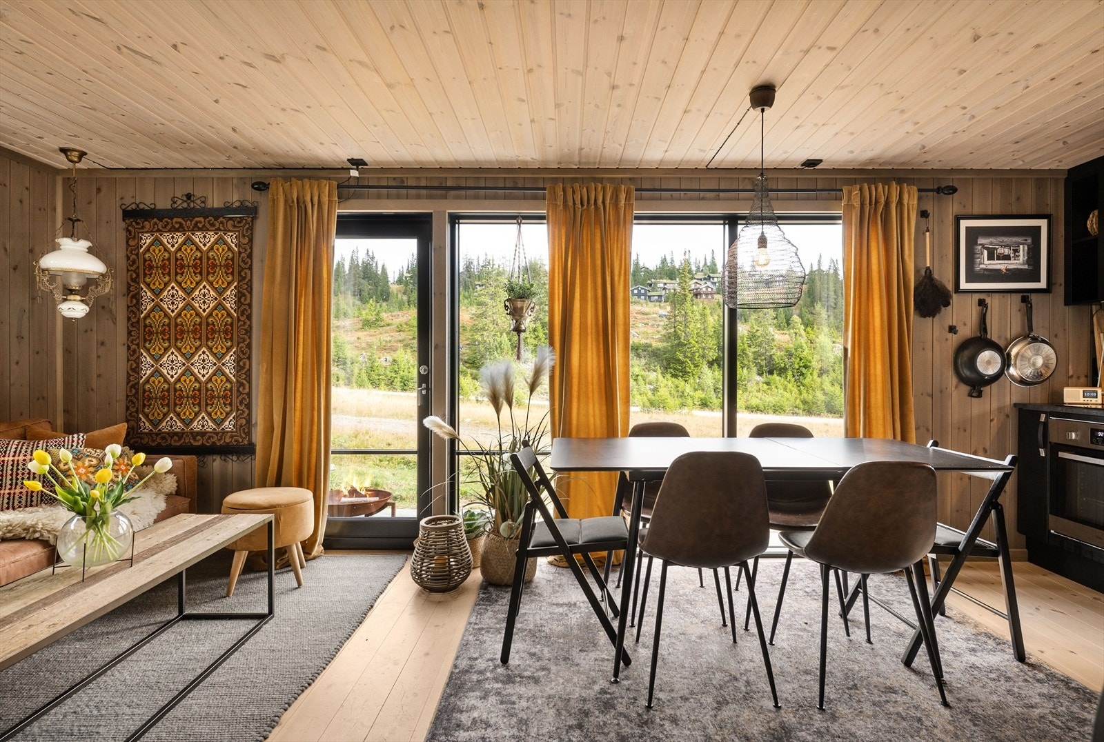 Åpen løsning mellom stue og kjøkken med plass til både sofagruppe og spisebord. Galleribilde