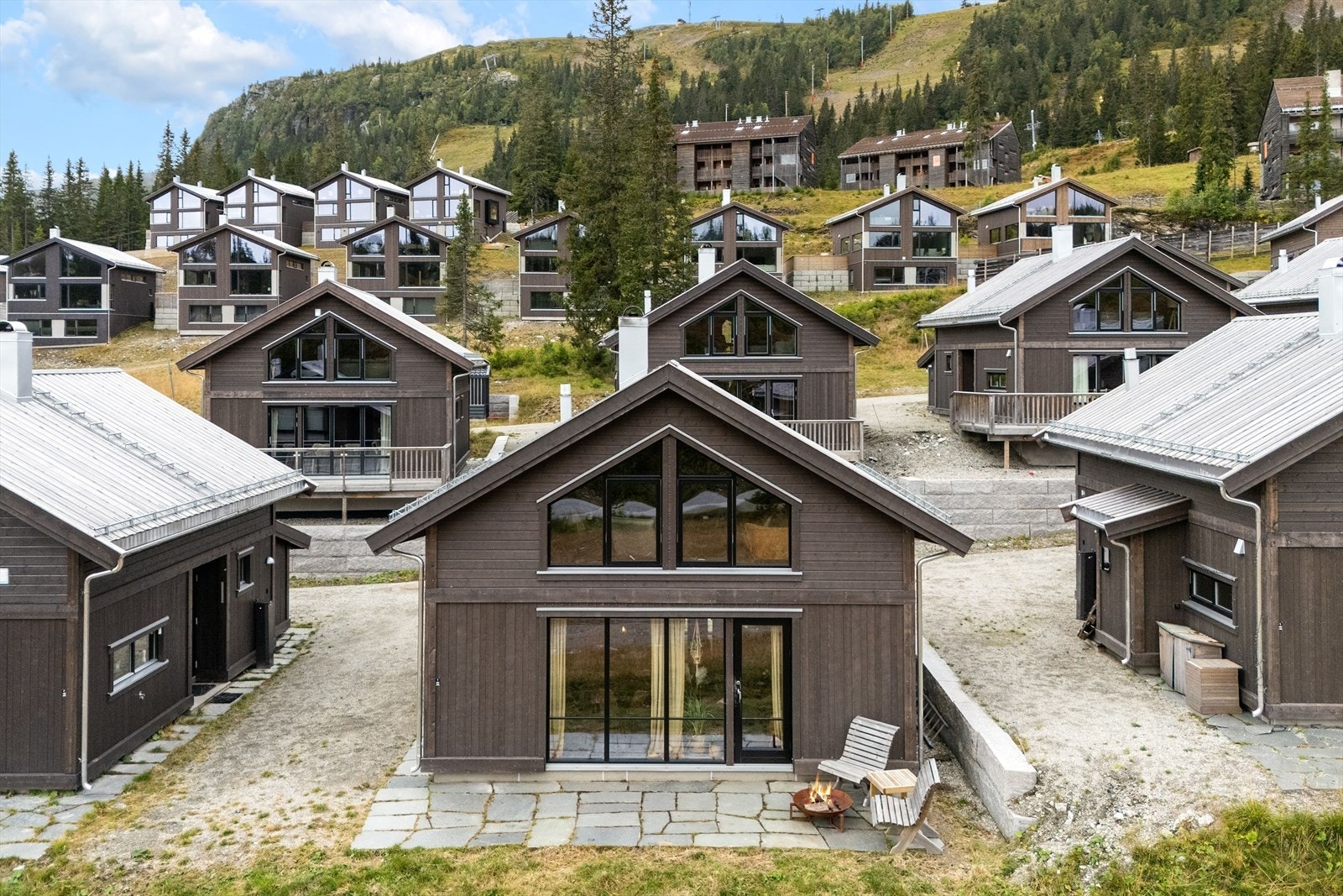 Hytta har en moderne arkitektur med stående og liggende trekledning. Galleribilde