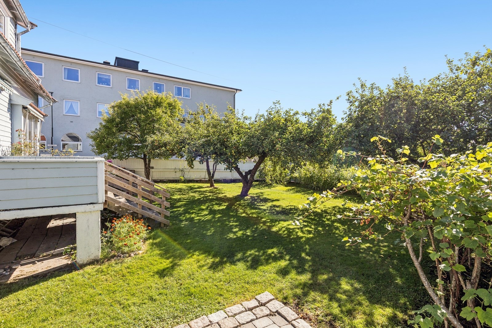 Pent opparbeidet hage med plen, trær, bedd, busker og blomster. Galleribilde