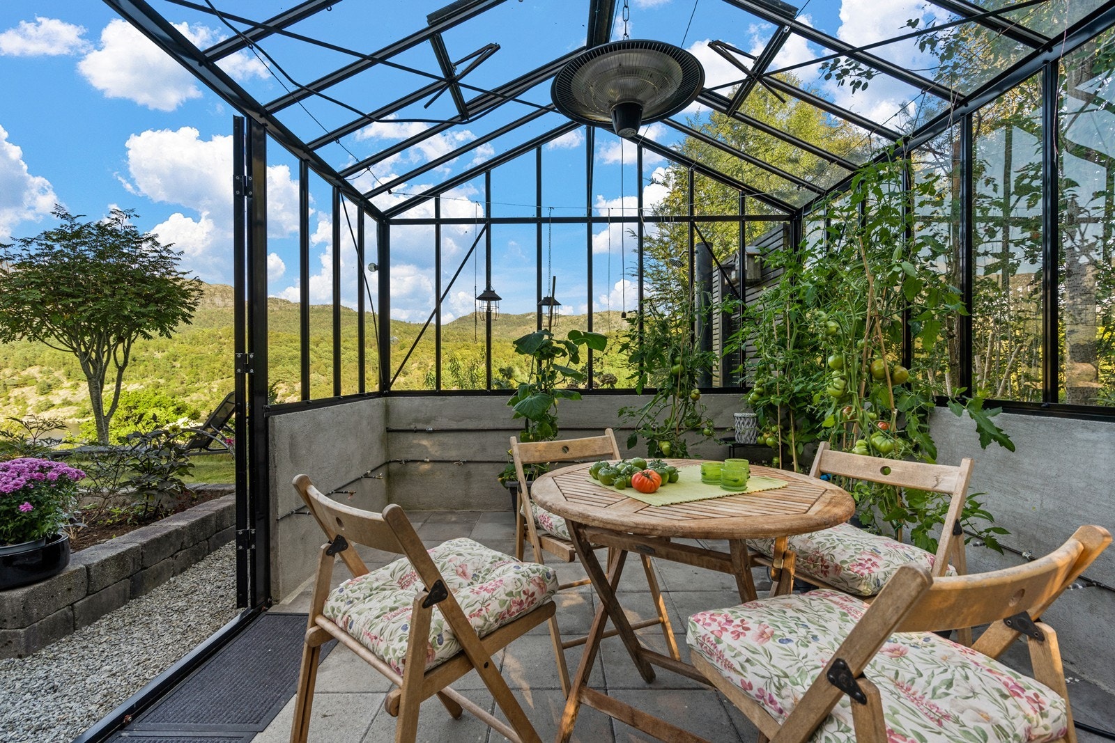 Drivhuset er innredet med spiseplass og god plass til plantedyrking. Galleribilde