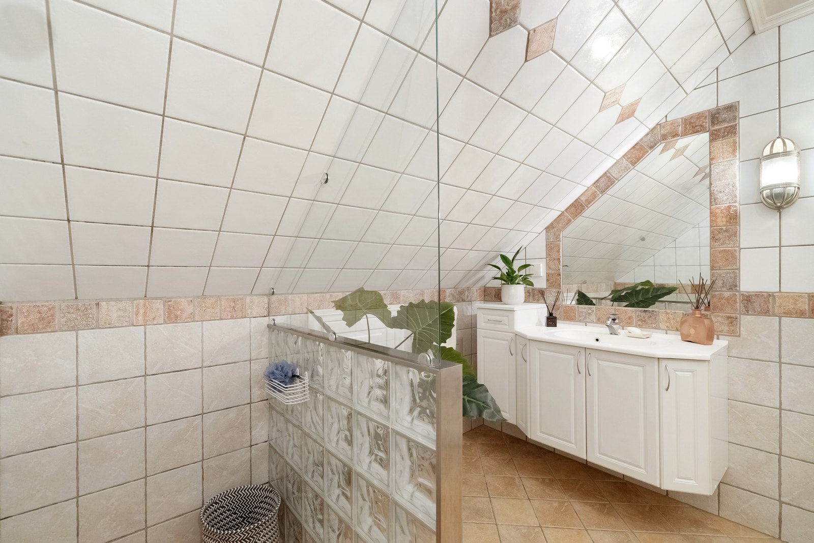 Badet har servantmøbel, speil, veggskap og gulvstående toalett. Galleribilde