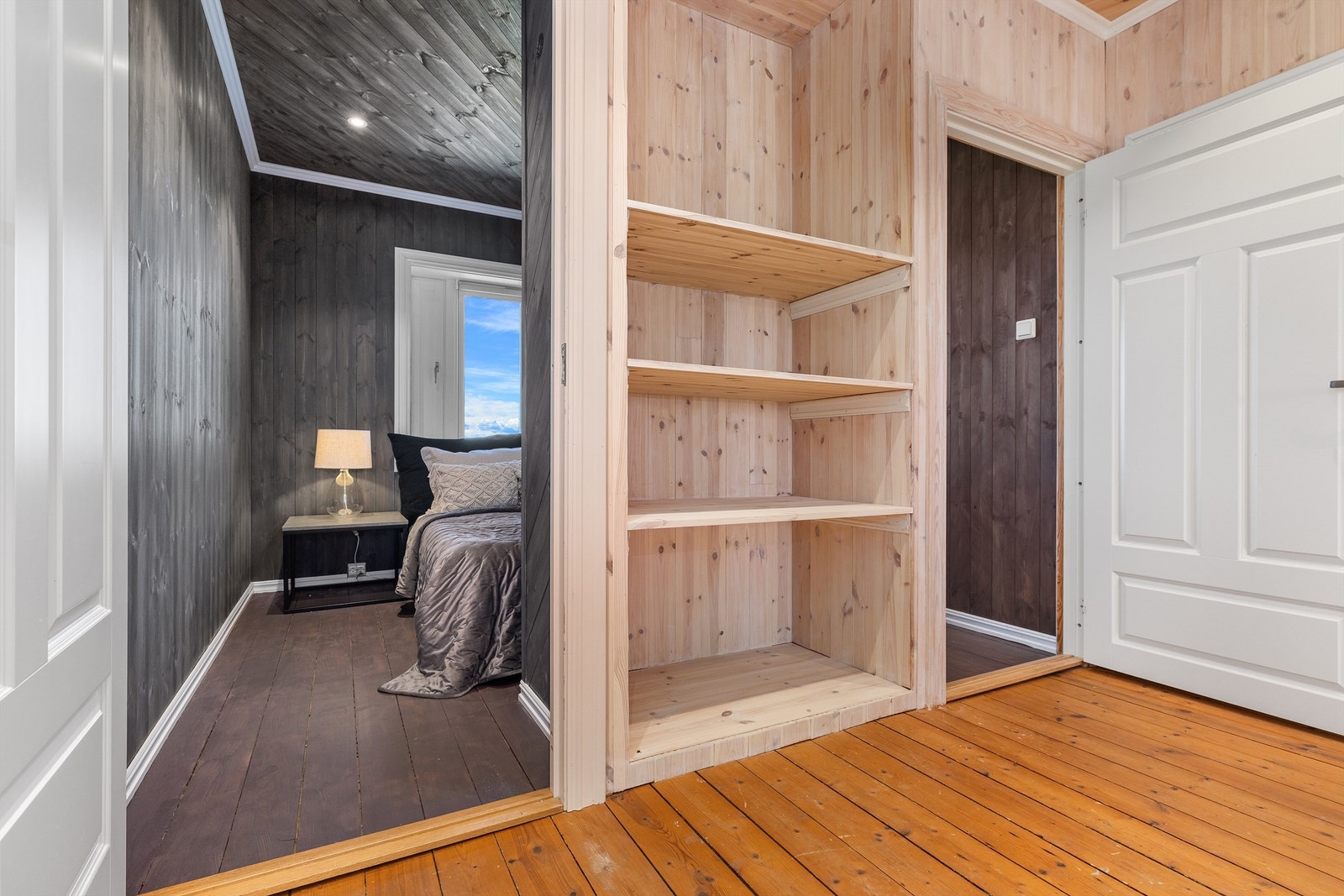 Innredet rom i loftsetasjen med mørkbeiset panel og tregulv. Galleribilde