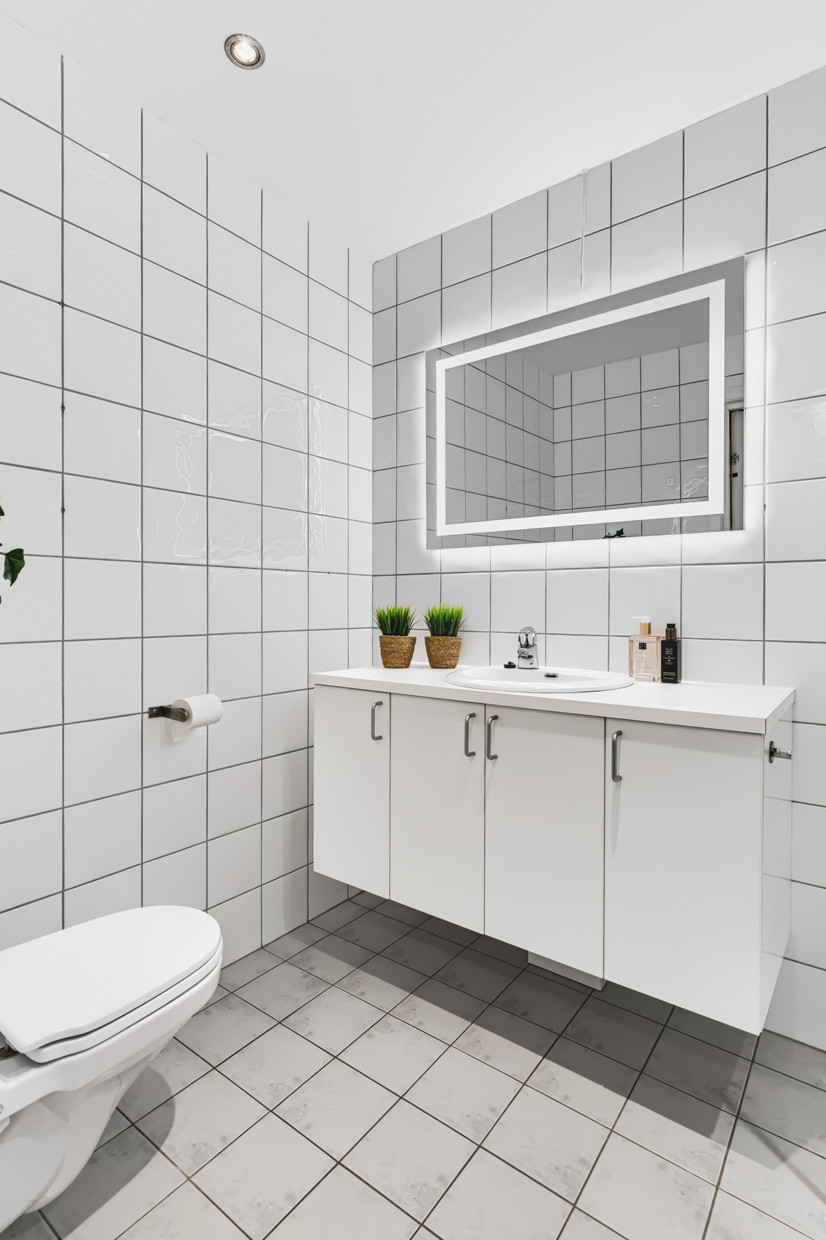 Badet har lyse flislagte vegger og praktisk innredning. Galleribilde