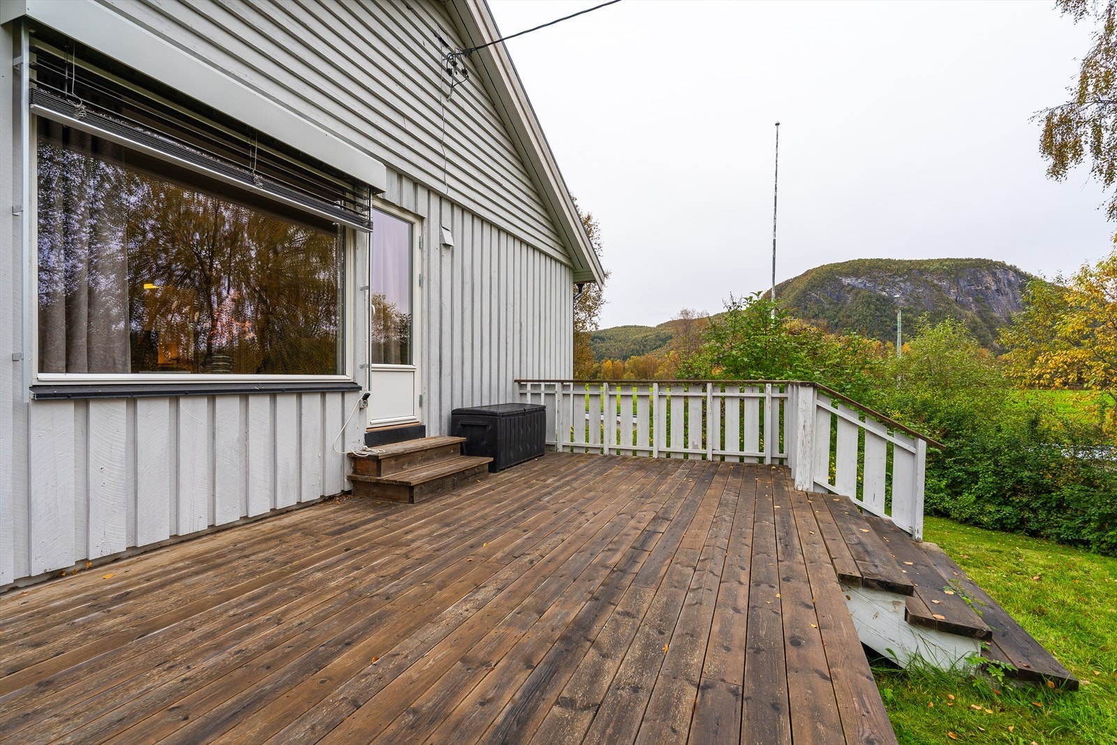 Utgang fra stuen til den store verandaen med trappetrinn ned til hagen. Galleribilde