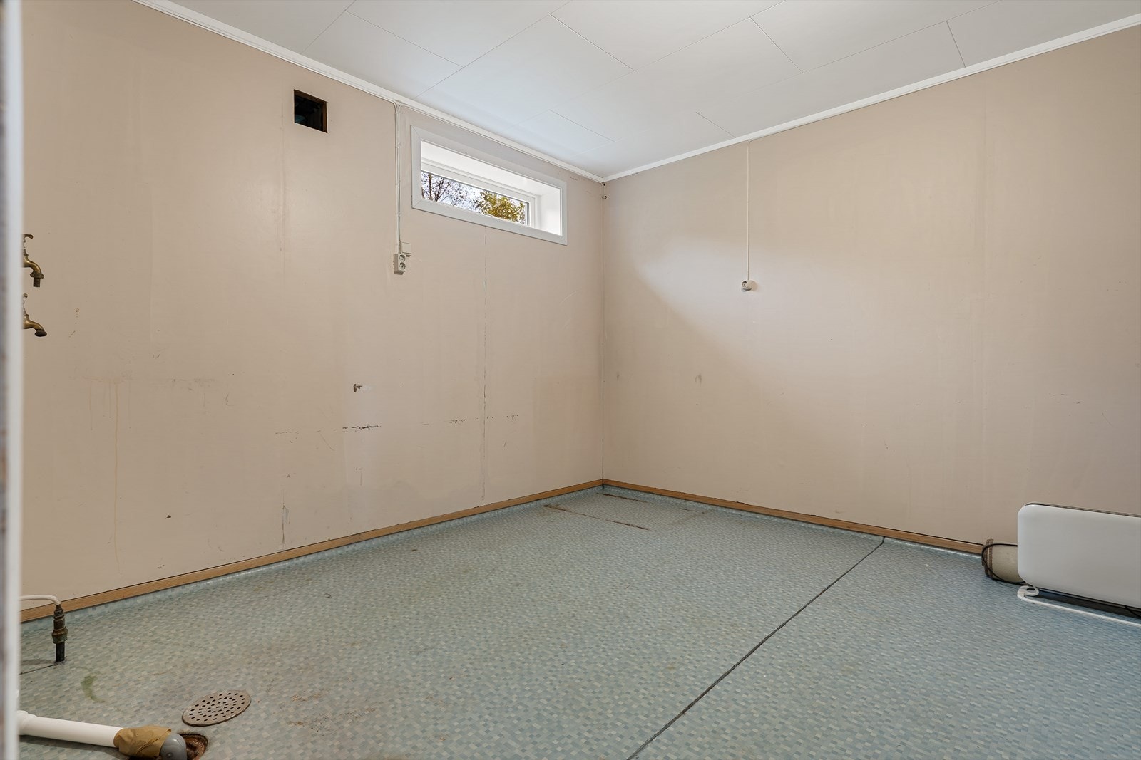 Vaskerom i kjeller med gulvvarme, sluk og opplegg for vaskemaskin. Galleribilde