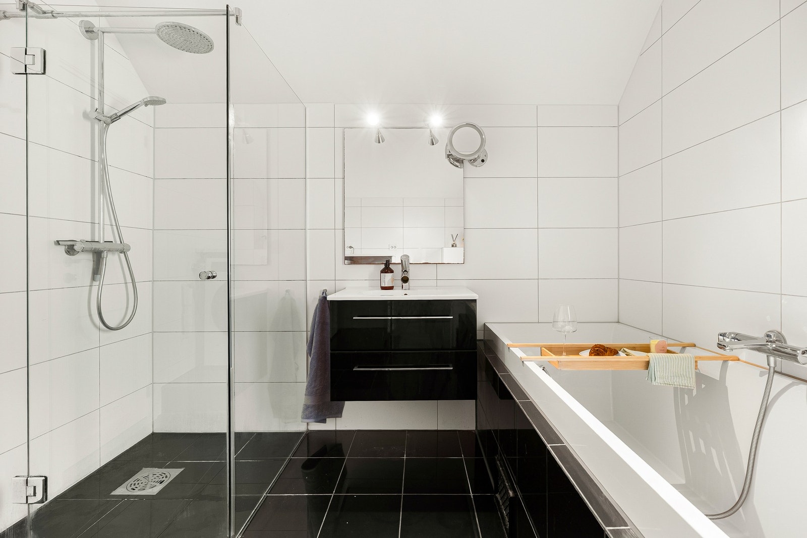 Badet er innredet med servant med oppbevaringsplass, vegghengt toalett, dusjhjørne med glassvegger og badekar. Galleribilde
