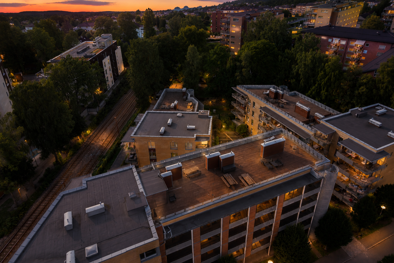 På toppen av bygget finner du en herlig takterrasse med flott utsyn over området og gode solforhold hele dagen - perfekt for sosiale sammenkomster. Skumringsbilde for illustrasjon. Galleribilde