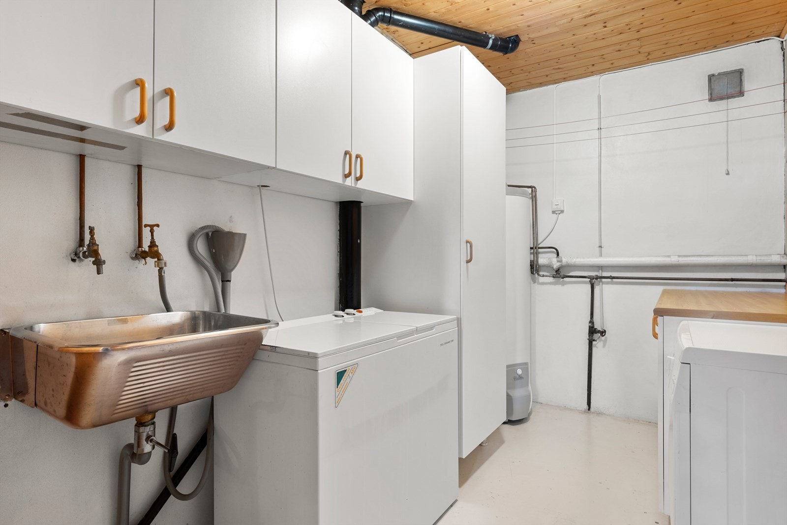 Praktisk vaskerom på 6,5 m² med god funksjonalitet og utstyrt med opplegg for vaskemaskin, varmtvannsbereder og utslagsvask. Galleribilde