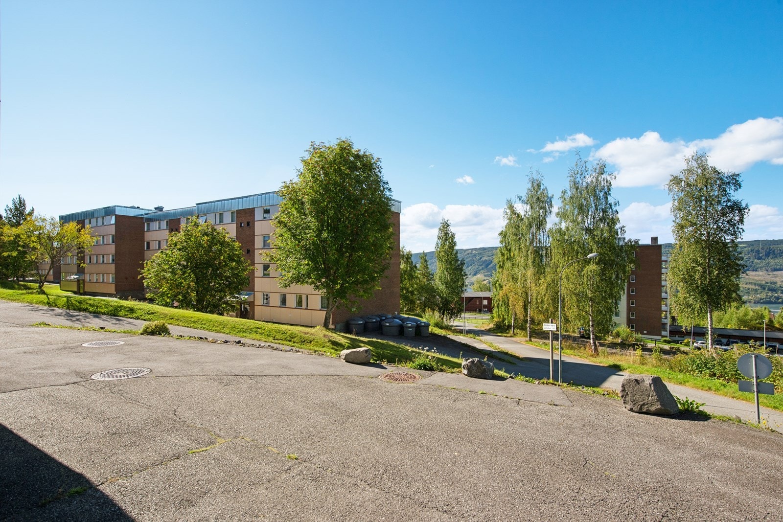 Boligen disponerer en biloppstillingsplass ved inngangspartiet, merket med leilighetsnummer. Galleribilde