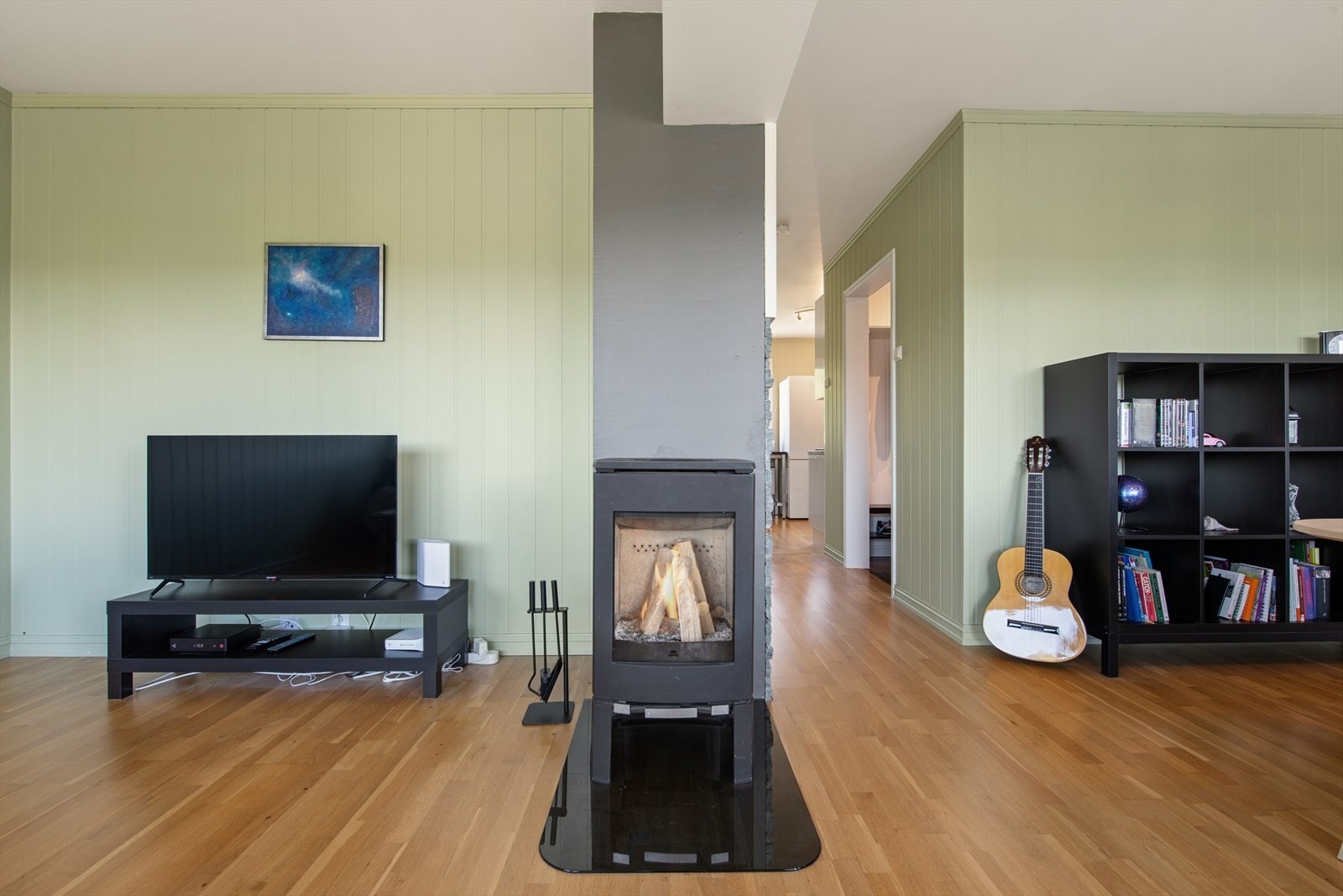 Vedovnen er montert sentralt i oppholdsrommet og fungerer som et naturlig samlingspunkt med både varme og hygge. Galleribilde