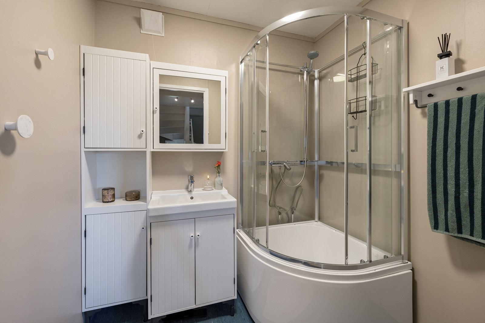 Badet i underetasjen er utstyrt med dusjkabinett, servant med underskap, speil og har naturlig ventilering. Galleribilde
