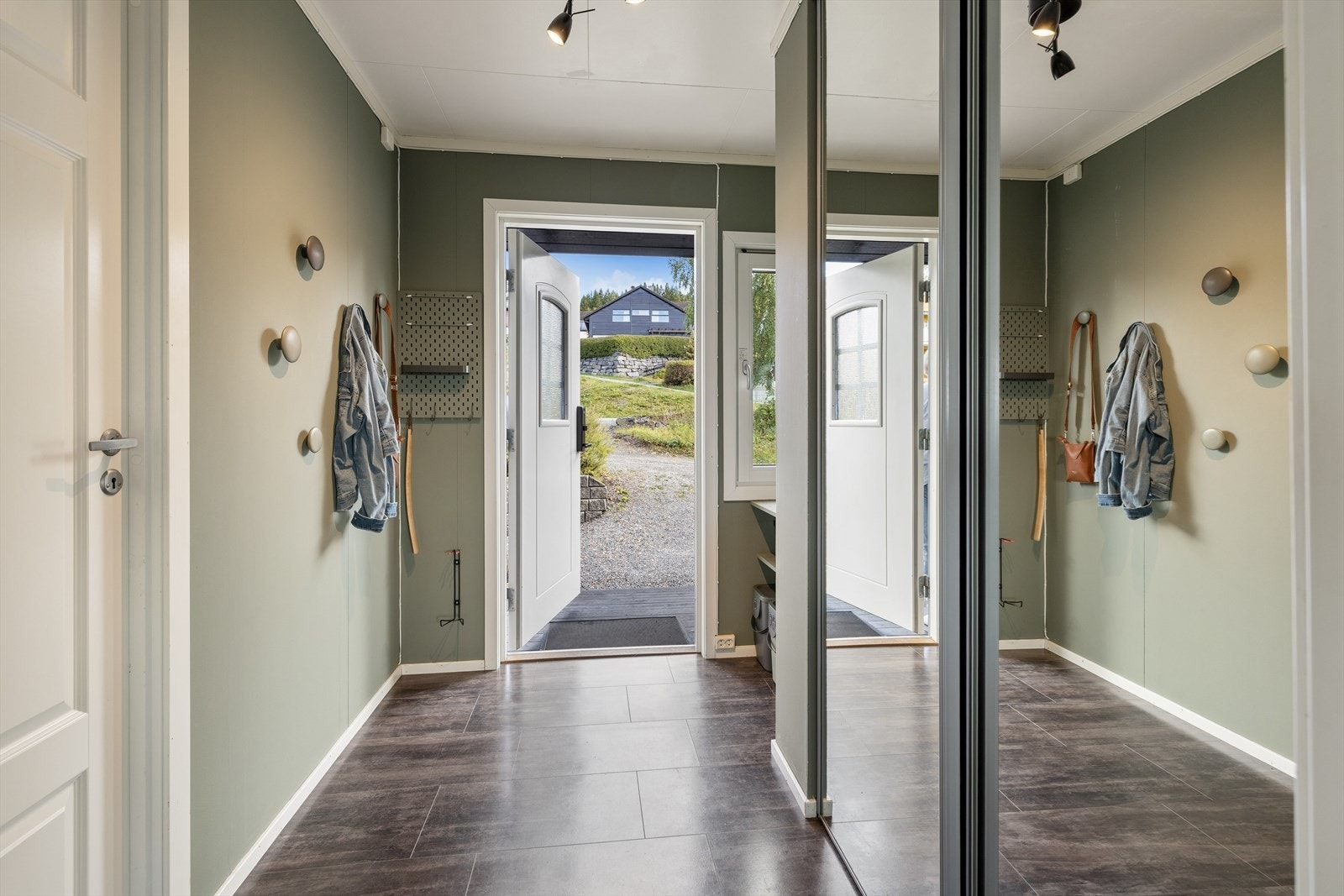 Entré med flislagt gulv og skyvedørsgarderobe med speilfronter. Galleribilde