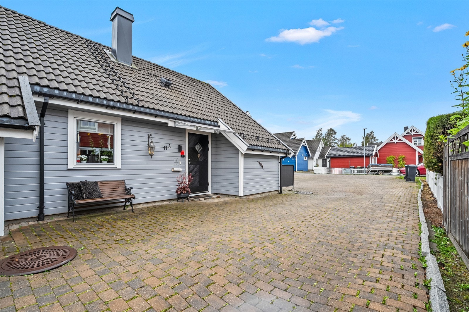 Hyggelig overbygget inngangsparti med profilert ytterdør og steinbelagt gårdsplass. Enkel adkomst til boligen. Galleribilde