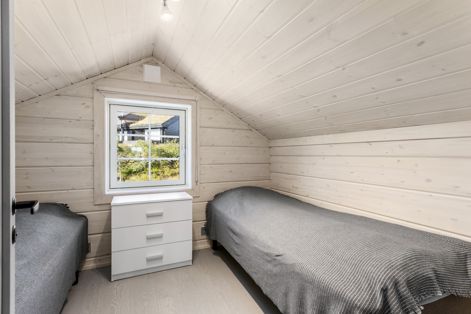 Det siste soverommet på loftet har skrå himling, lune panelflater og god plass til seng. Et hyggelig og praktisk rom som også passer godt som gjesterom. Galleribilde