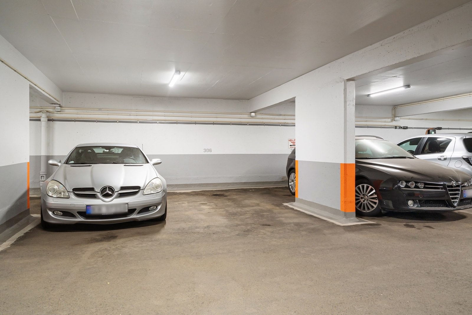 Fast biloppstillingsplass merket 306 med elbillader i felles garasjeanlegg. Galleribilde