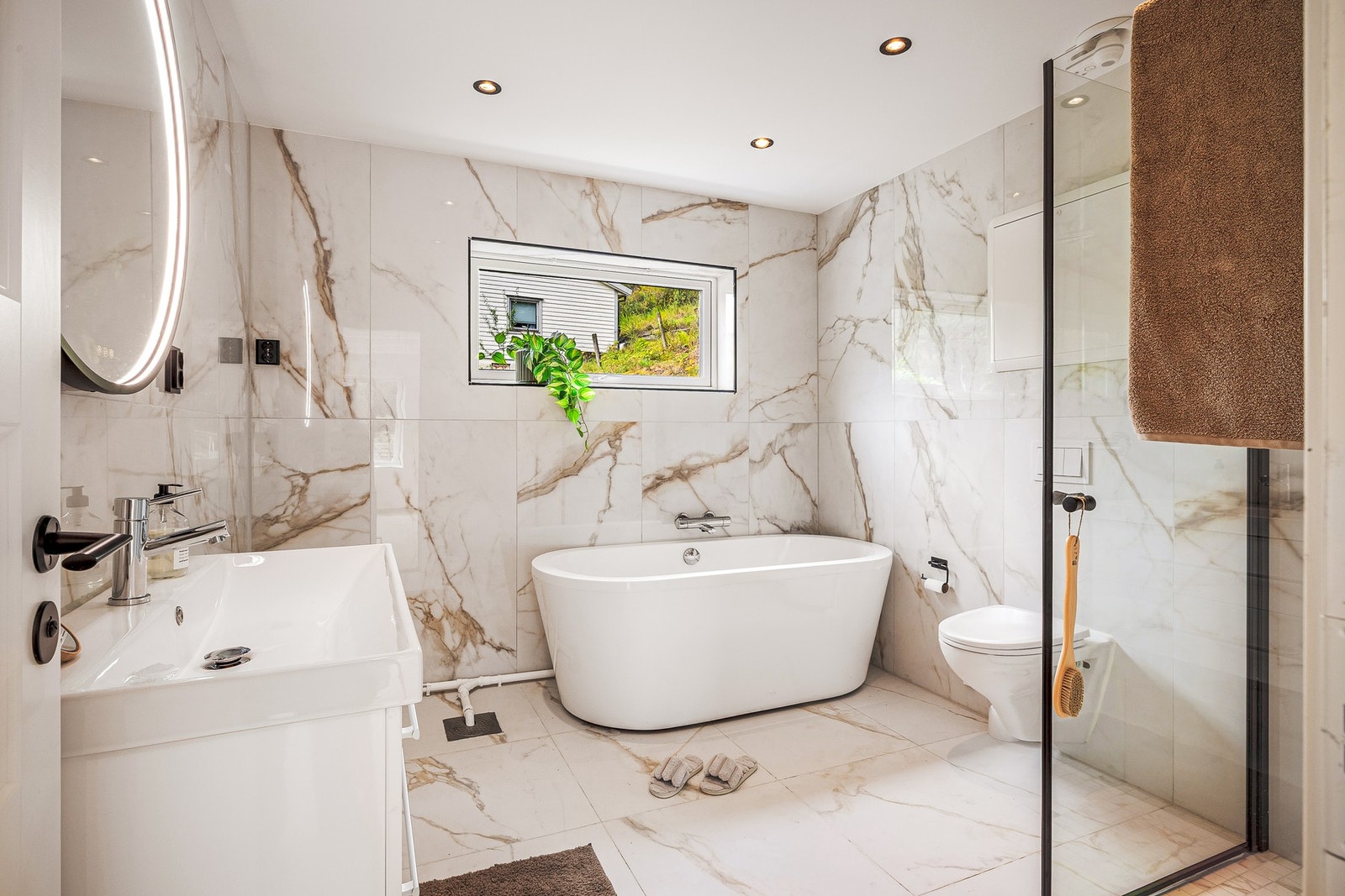 Badet er helfliset og har slett, malt himling med innfelte downlights. Galleribilde