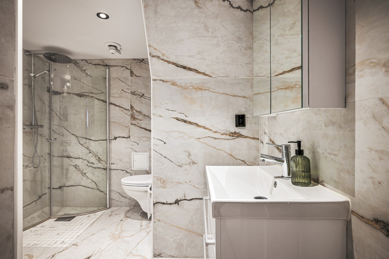 Badet er helfliset og har slett, malt himling med innfelte downlights. Det er varmekabler i gulv. Galleribilde