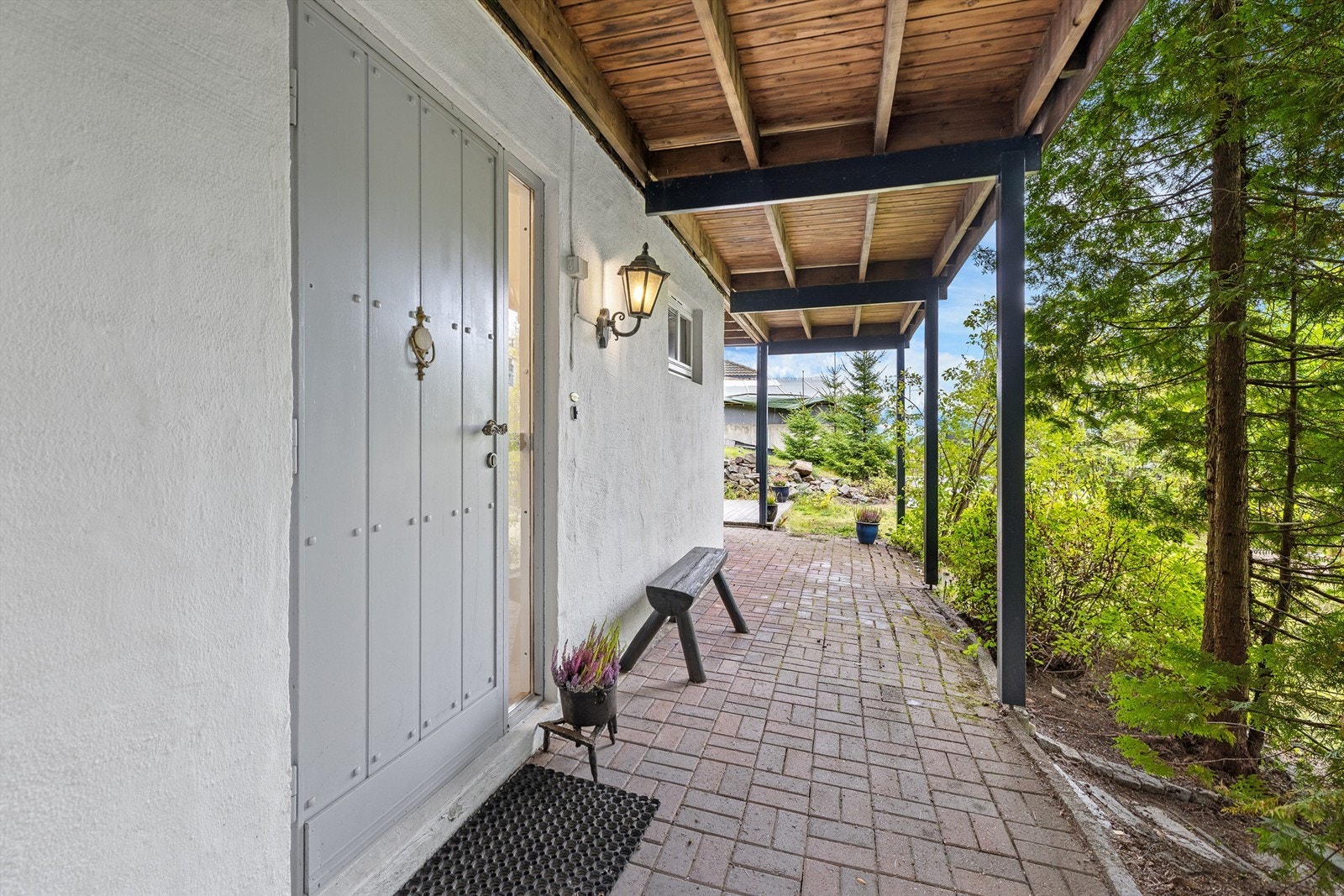 Overbygget inngangsparti med belegningsstein. Galleribilde