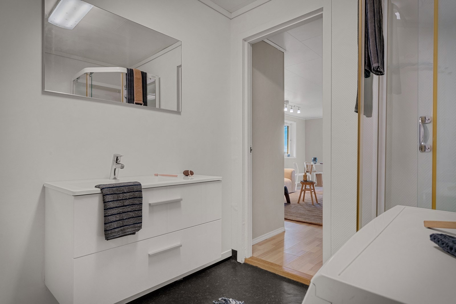 Badet i hybelen har gulvvarme, servantmøbel med skuffer og speil med belysning. Galleribilde