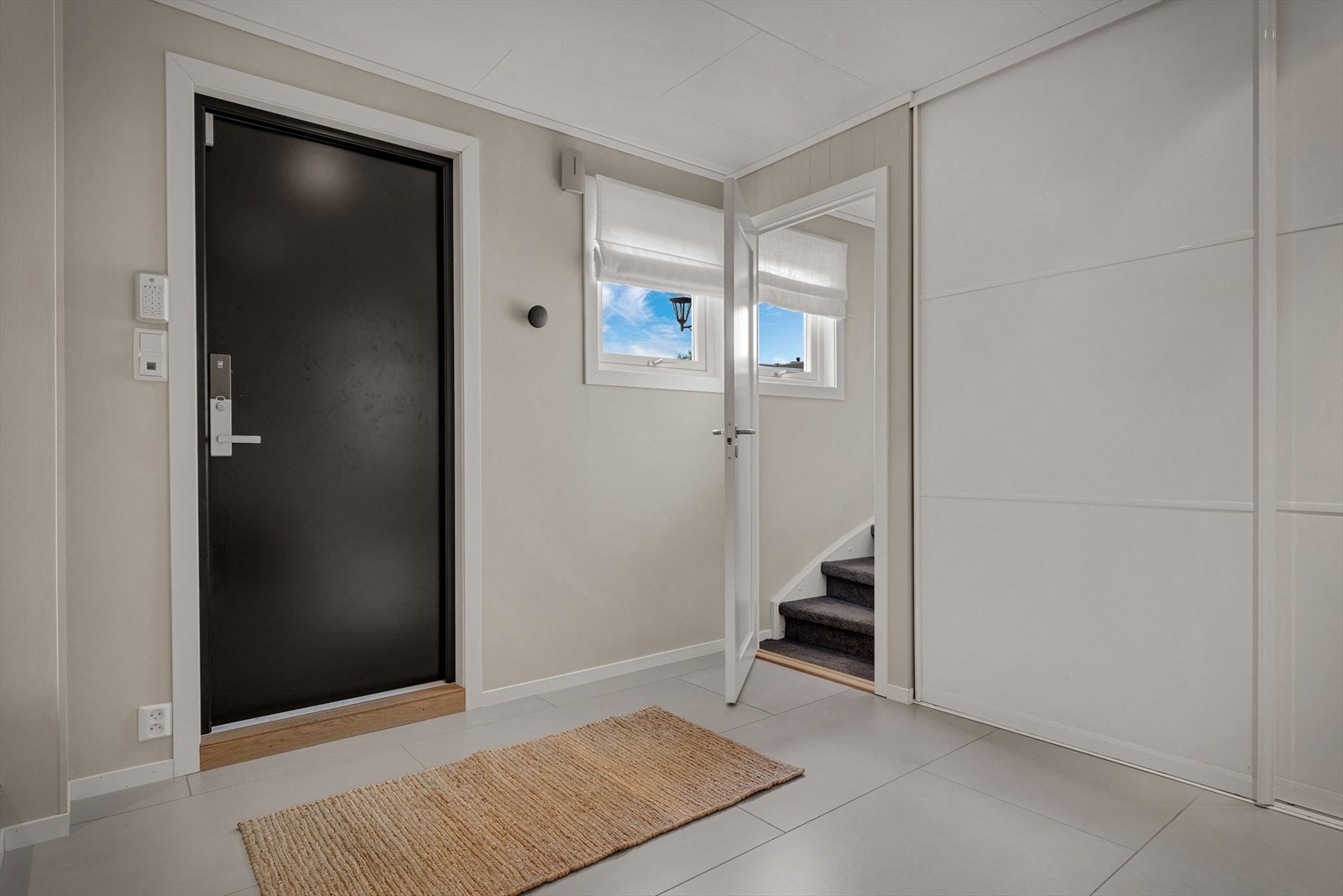 Tilbyggets bi-inngang har flislagt gulv med varmekabler, skyvedørsgarderobe og trapp opp til loftsetasjen. Galleribilde