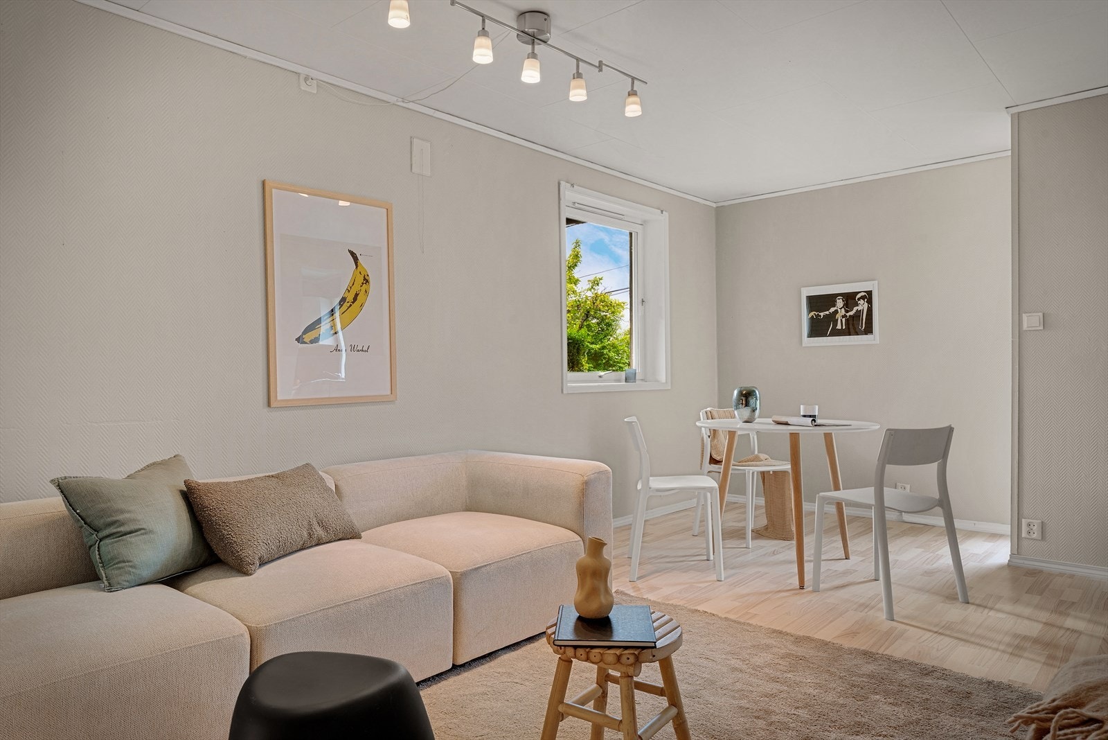 Stuen i utleiedelen har plass til spisebord og har vindu ut mot grønne omgivelser. Galleribilde