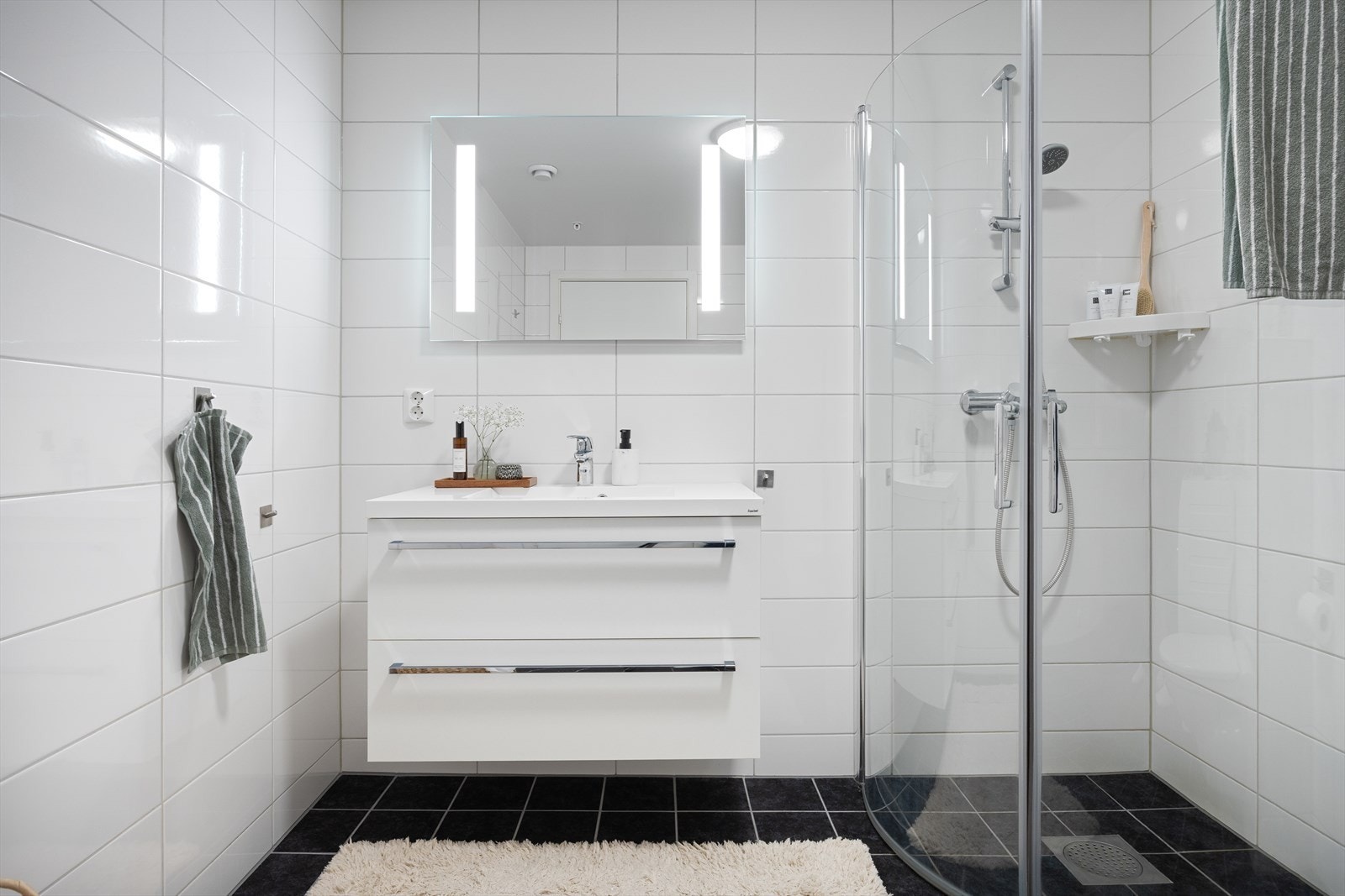 Badet er fra 2019 og fremstår lyst og delikat - av sanitærutstyr er det både servant med oppbevaringsplass, vegghengt wc og dusjsone med foldedører. Galleribilde